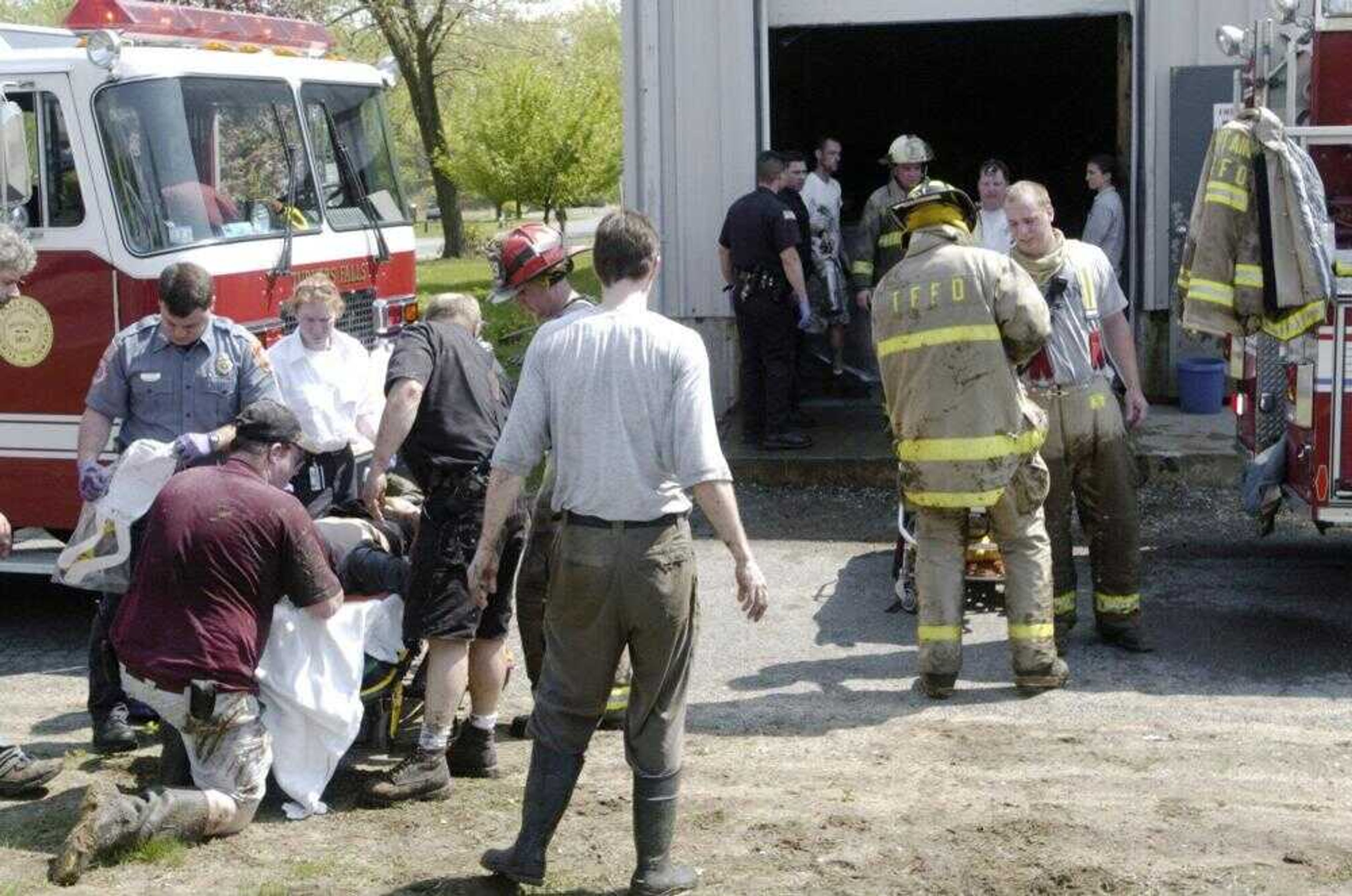 A worker, on stretcher at left, was removed from the building after he and three co-workers were trapped Friday in a fiberglass tank of dense fish feces for 45 minutes. Flooring supports collapsed as the men were cleaning the tank at the Australis Aquaculture fish farm in Turners Falls, Mass. (PAUL FRANZ ~ Greenfield Recorder)