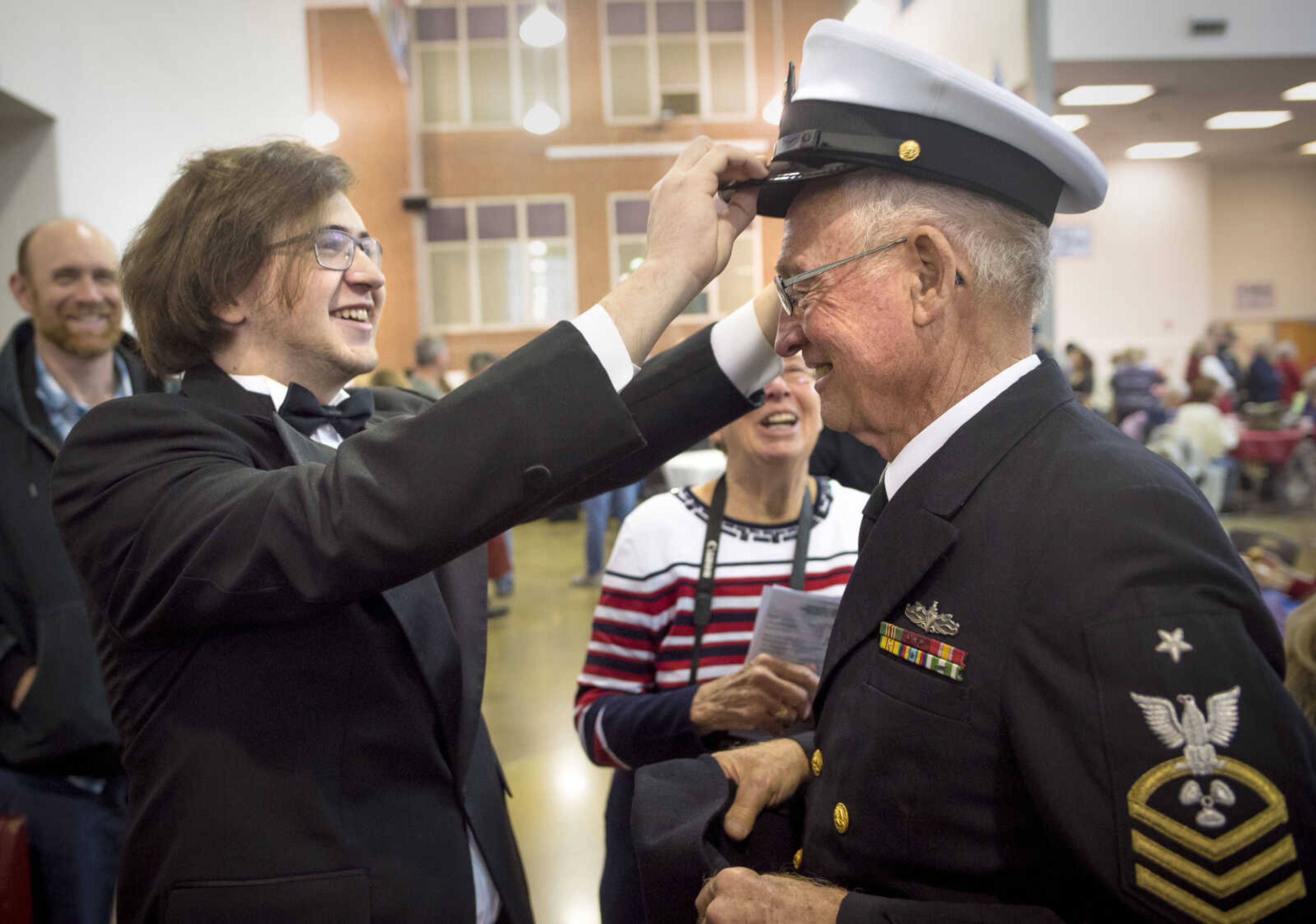 Jackson senior Joshua Miller, left, straightens a cap worn by his grandfather Arlin Miller after an assembly to honor veterans Monday, Nov. 11, 2019, at Jackson High School. Arlin Miller is a retired Navy senior chief machinist mate who served from 1963 to 1986.