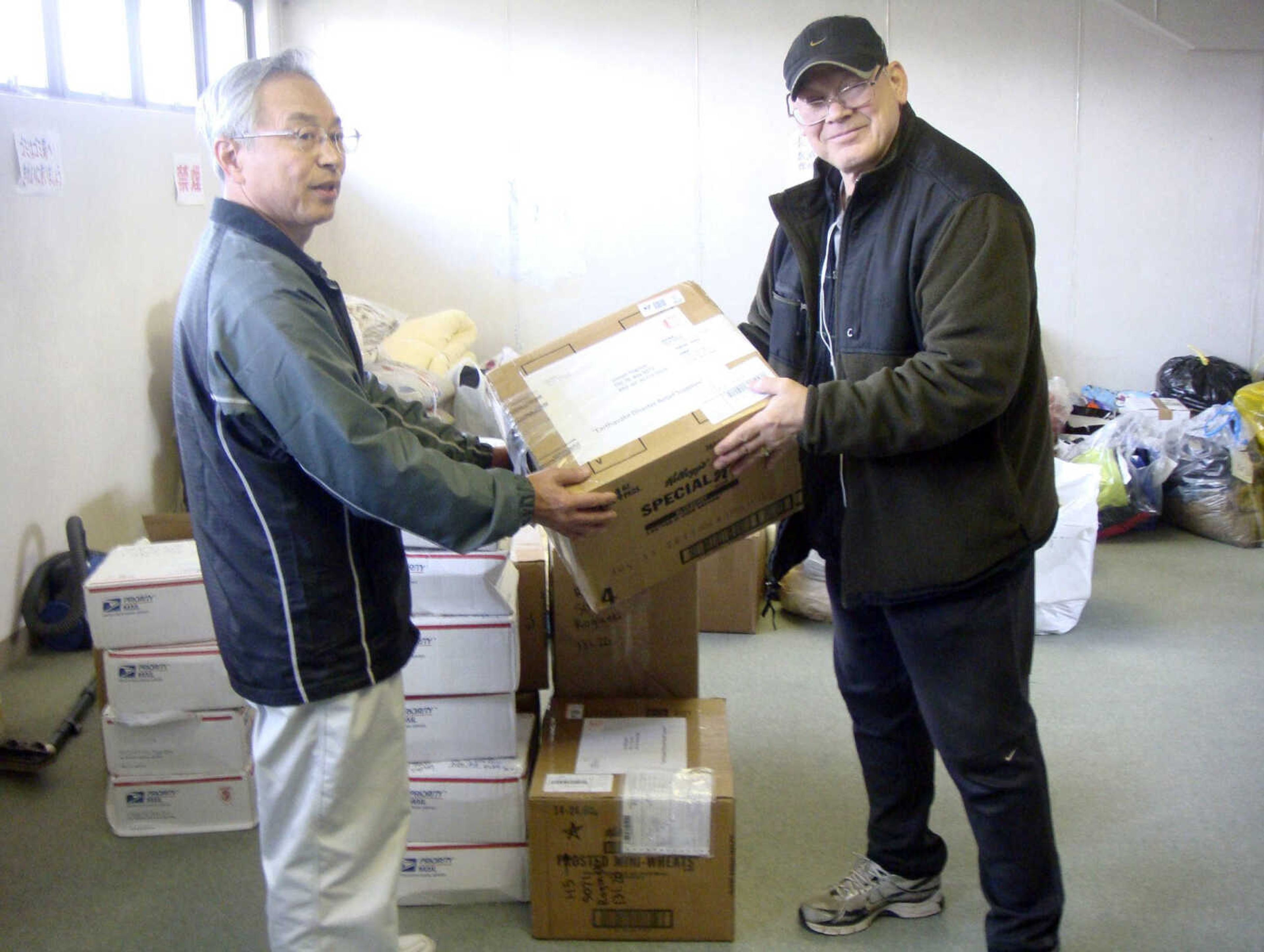 Joseph Roginski, right, holds a package May 13, 2011, in a storeroom of the Misawa City Hall in Japan, where donations of clothing and supplies were being kept for earthquake-relief efforts.