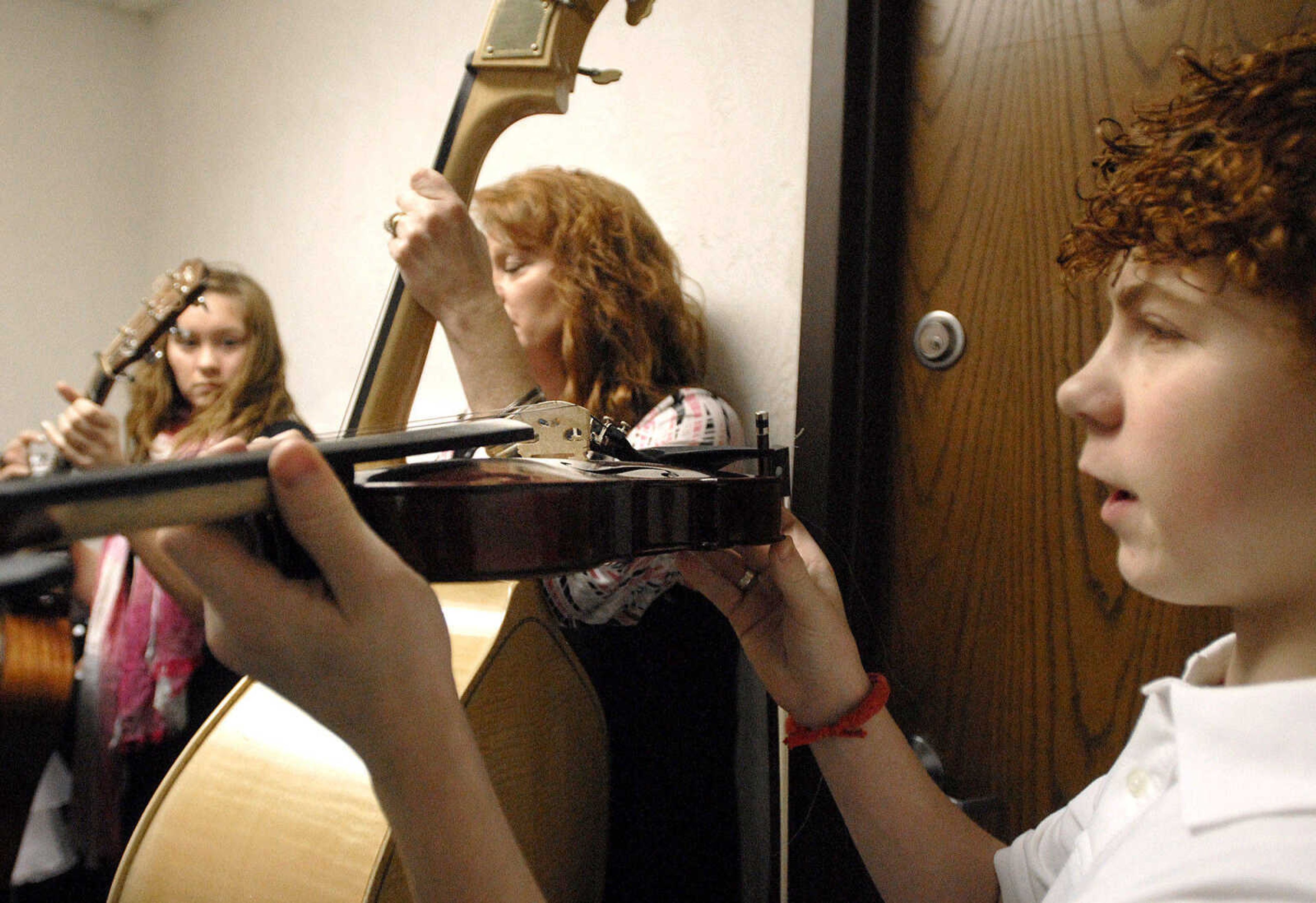 LAURA SIMON ~ lsimon@semissourian.com
Magan Lewis, left, Jeanne Lewis, center, and Brandon Calhoun practice before they take the stage Thursday night, January 26, 2012 during the Bootheel Bluegrass Festival at the Bavarian Halle in Fruitland