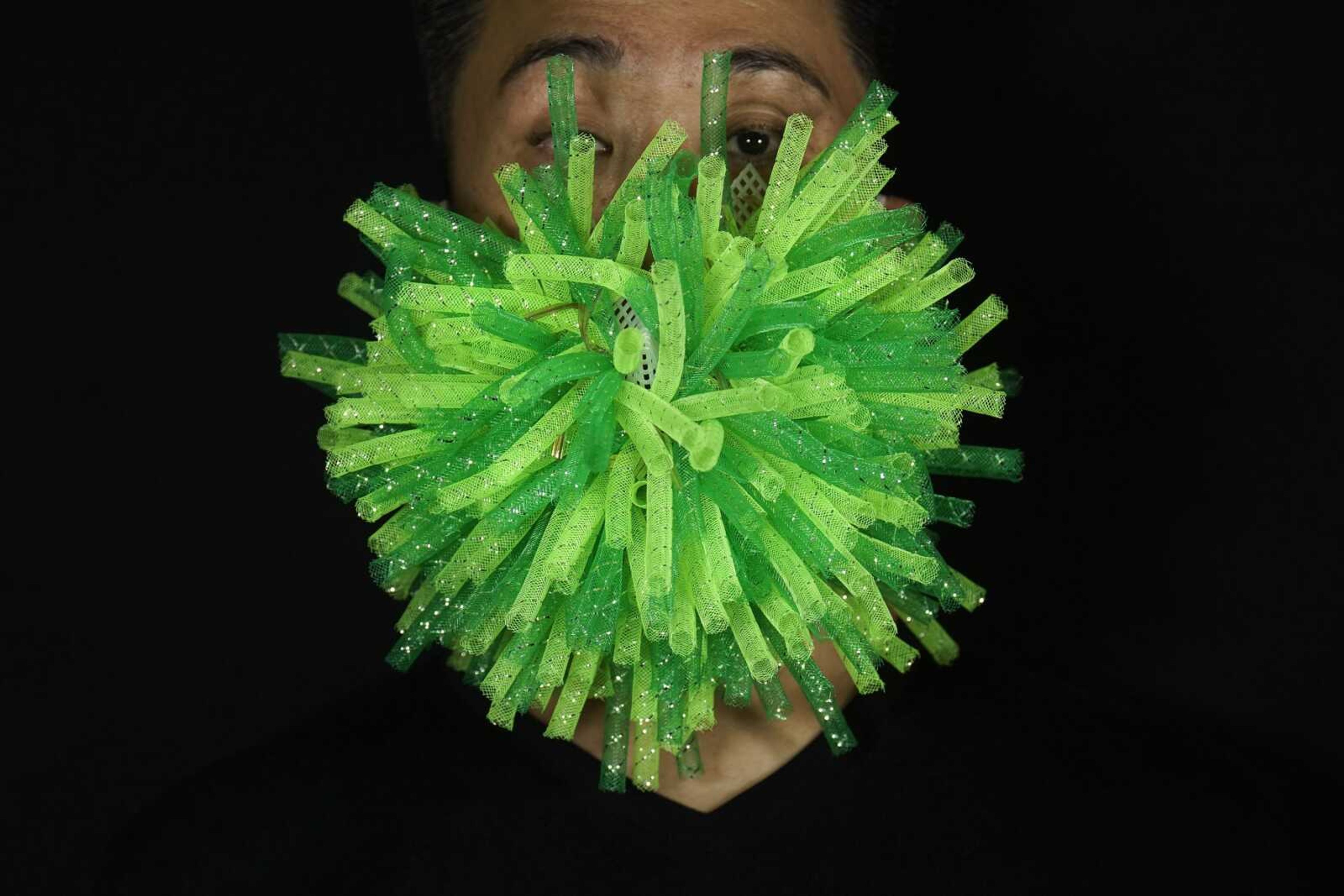 Edmond Kok, a Hong Kong theater costume designer and actor, wears a spiky green mask, which is a 3D visualization of coronavirus, Aug. 6 in Hong Kong.