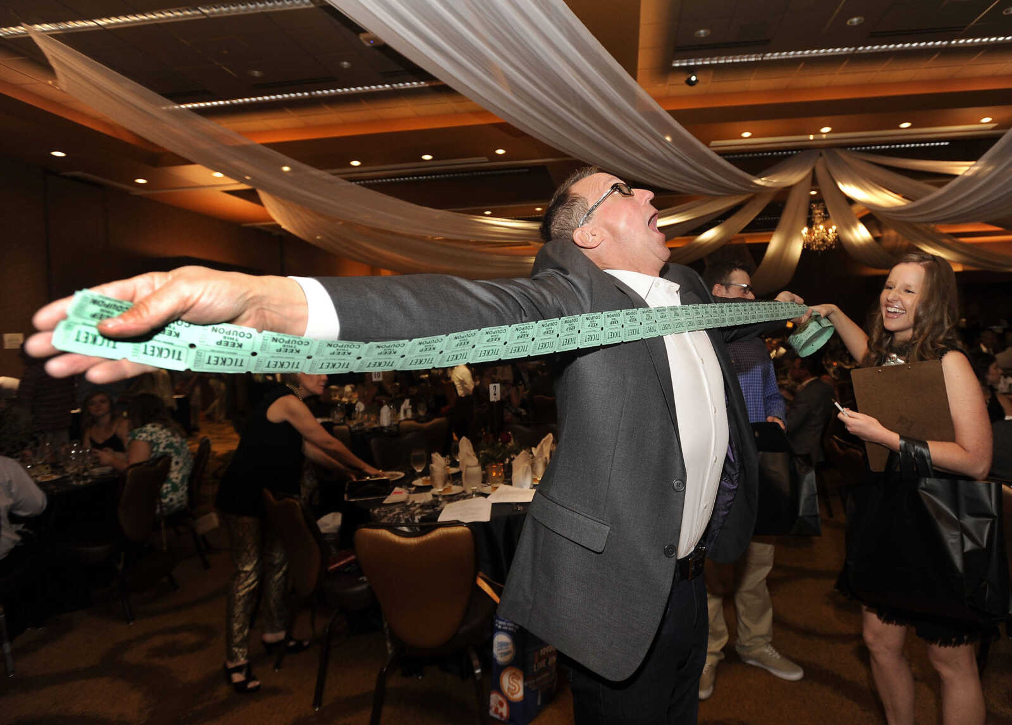 FRED LYNCH ~ flynch@semissourian.com
Chris Hutson measures an arm's length of raffle tickets for $10 with Christa Zickfield on Saturday, Sept. 9, 2017 at the 30th annual Charles L. Hutson Auction benefiting Old Town Cape at Isle Casino Cape Girardeau Event Center.