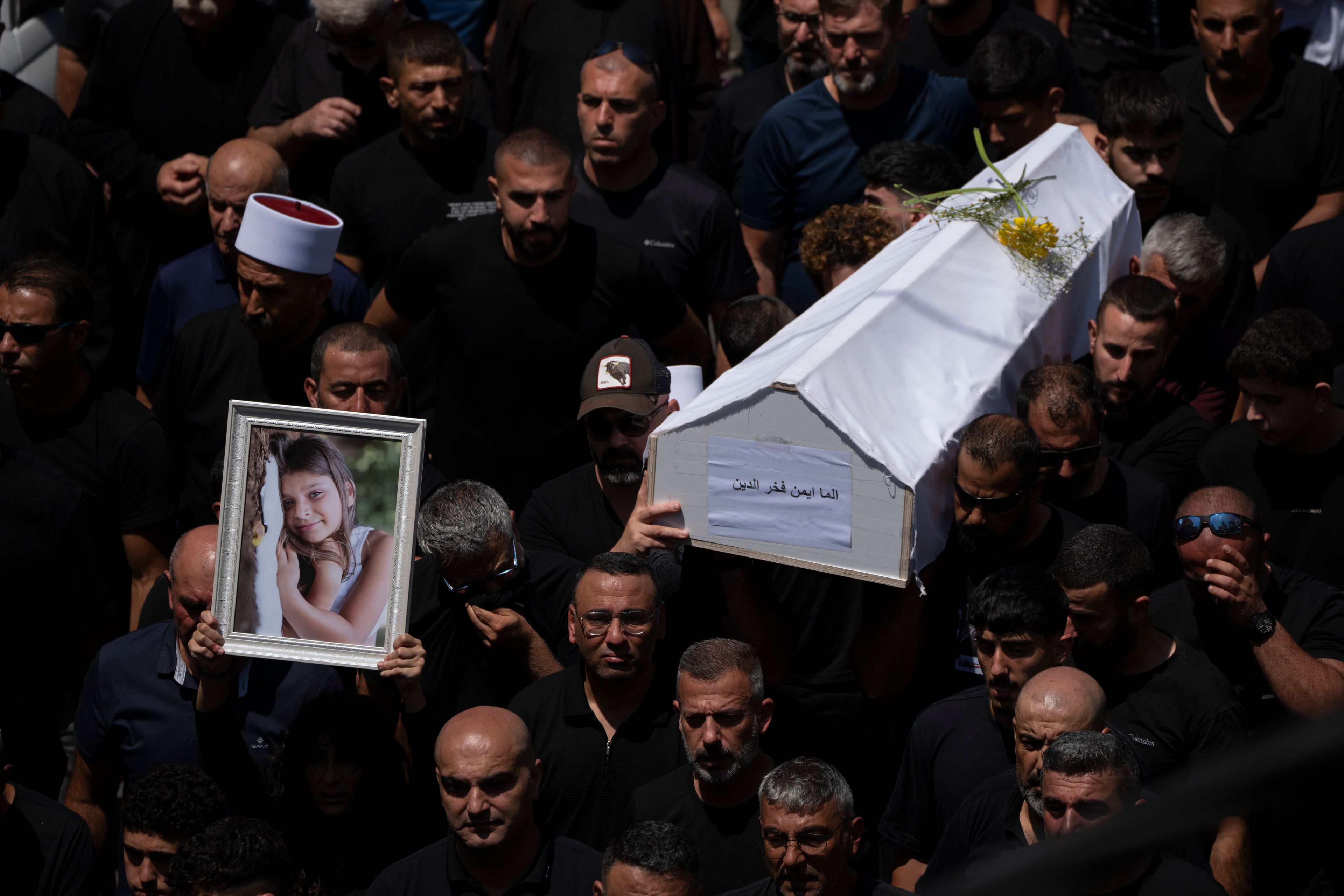 Mourners from the Druze minority carry the coffins of some of the 12 children and teens killed in a rocket strike at a soccer field during their funeral, in the village of Majdal Shams, in the Israeli-annexed Golan Heights, Sunday, July 28, 2024. It's the deadliest strike on an Israeli target along the country's northern border since the fighting between Israel and the Lebanese militant group Hezbollah began. (AP Photo/Leo Correa)