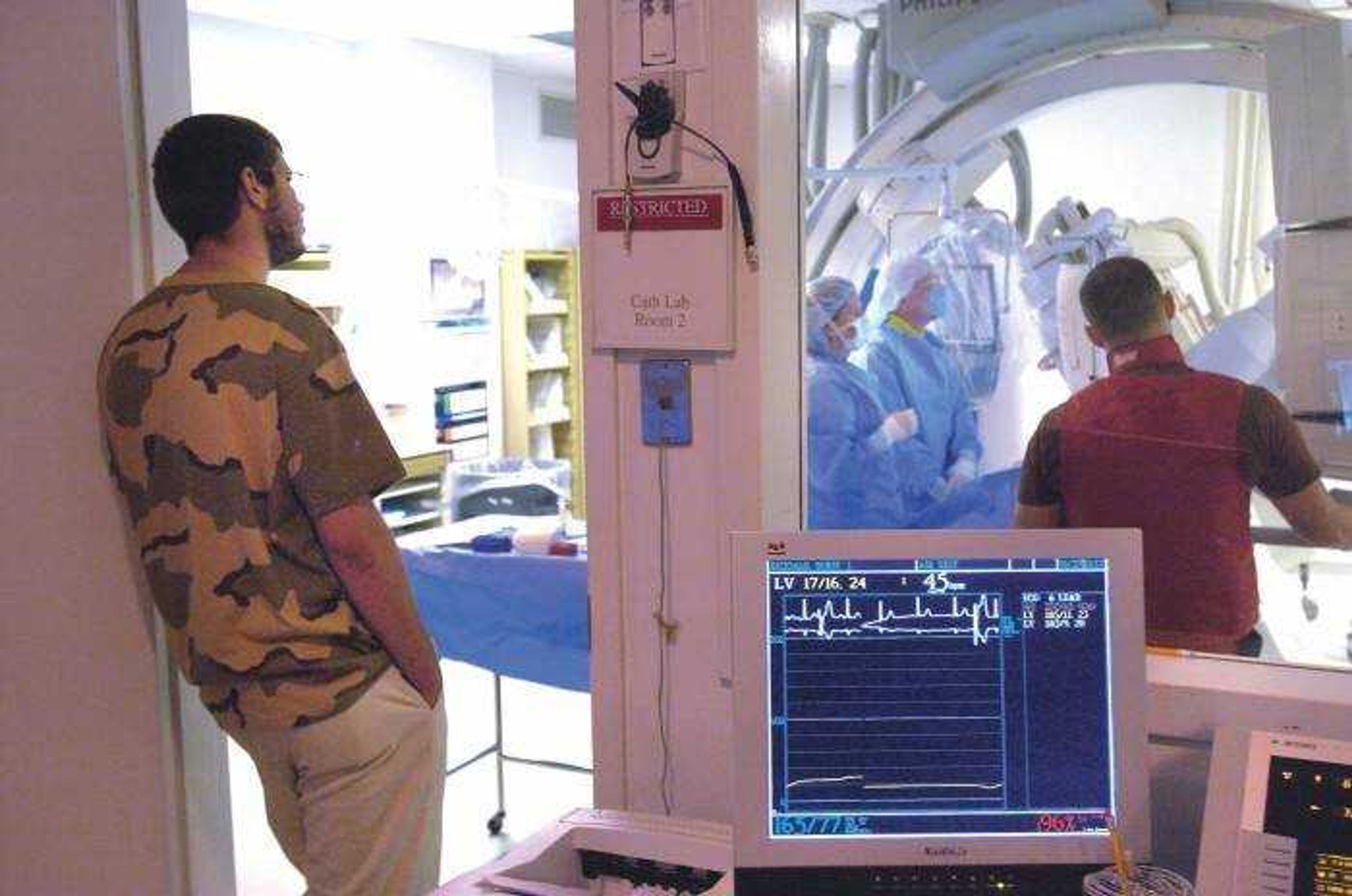 Cory Smith, left, of Jackson observed registered nurse Dustin Mattison, right, working in the cardiac cath lab at Southeast Missouri Hospital Tuesday while attending the nursing camp for high school boys.