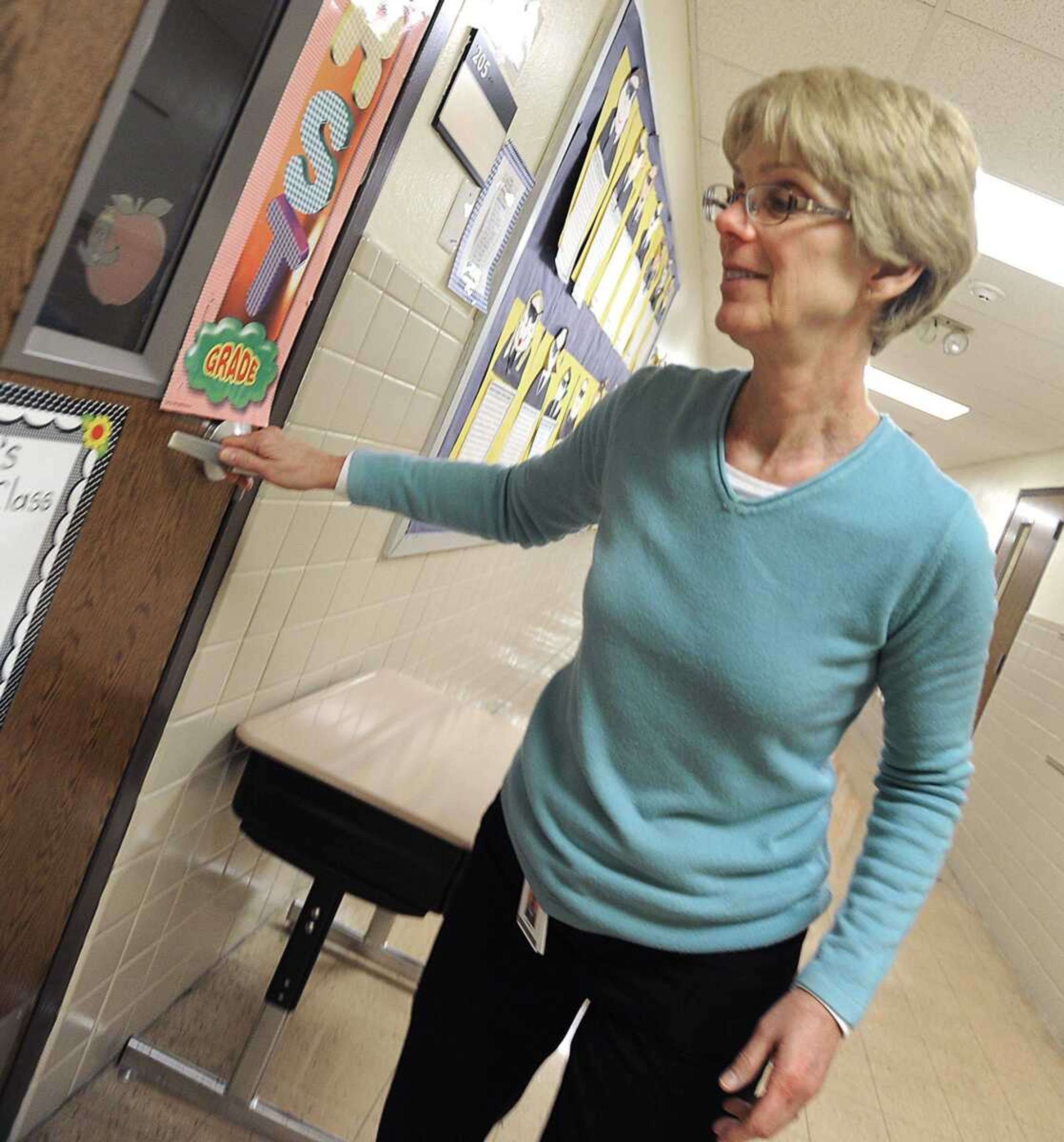 Kathy Swoboda, administrative assistant at Alma Schrader Elementary School, checks for locked classroom doors during an intruder alert drill Thursday in Cape Girardeau. (FRED LYNCH ~ flynch@semissourian.com)