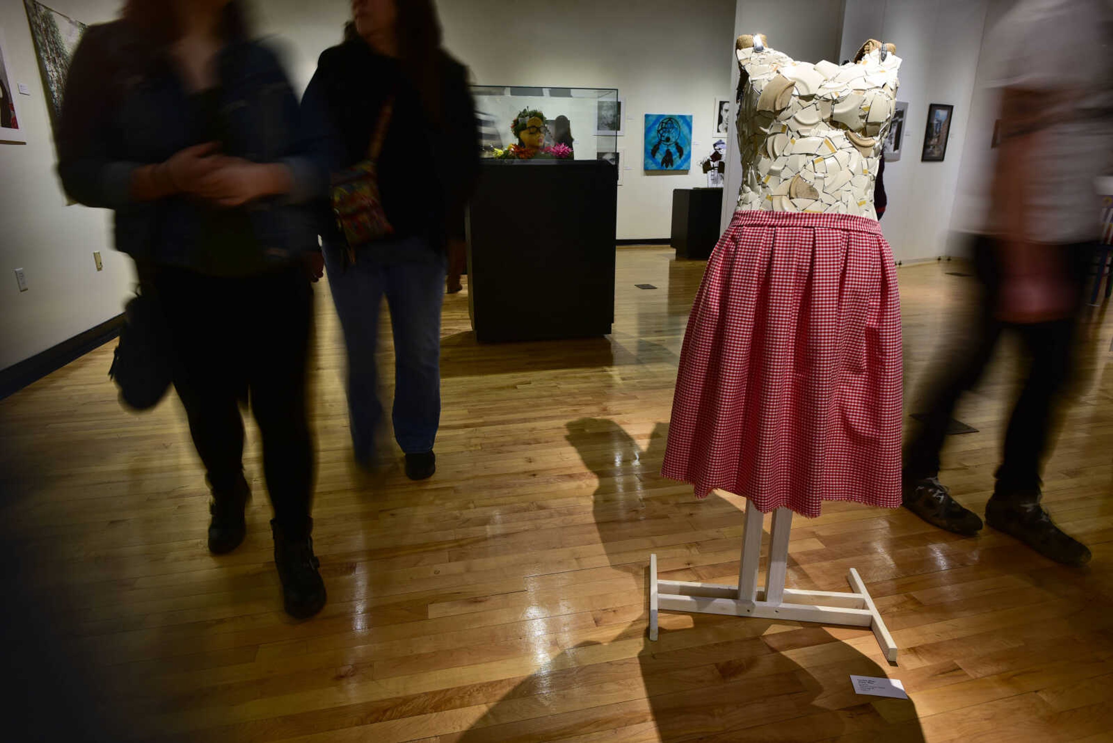 Guests walk the show floor as Oak Ridge student Caroline Abner's sculpture "Dinner Wear" sits on display at a high school art exhibition Sunday, Feb. 18, 2018, at Crisp Museum in Cape Girardeau.