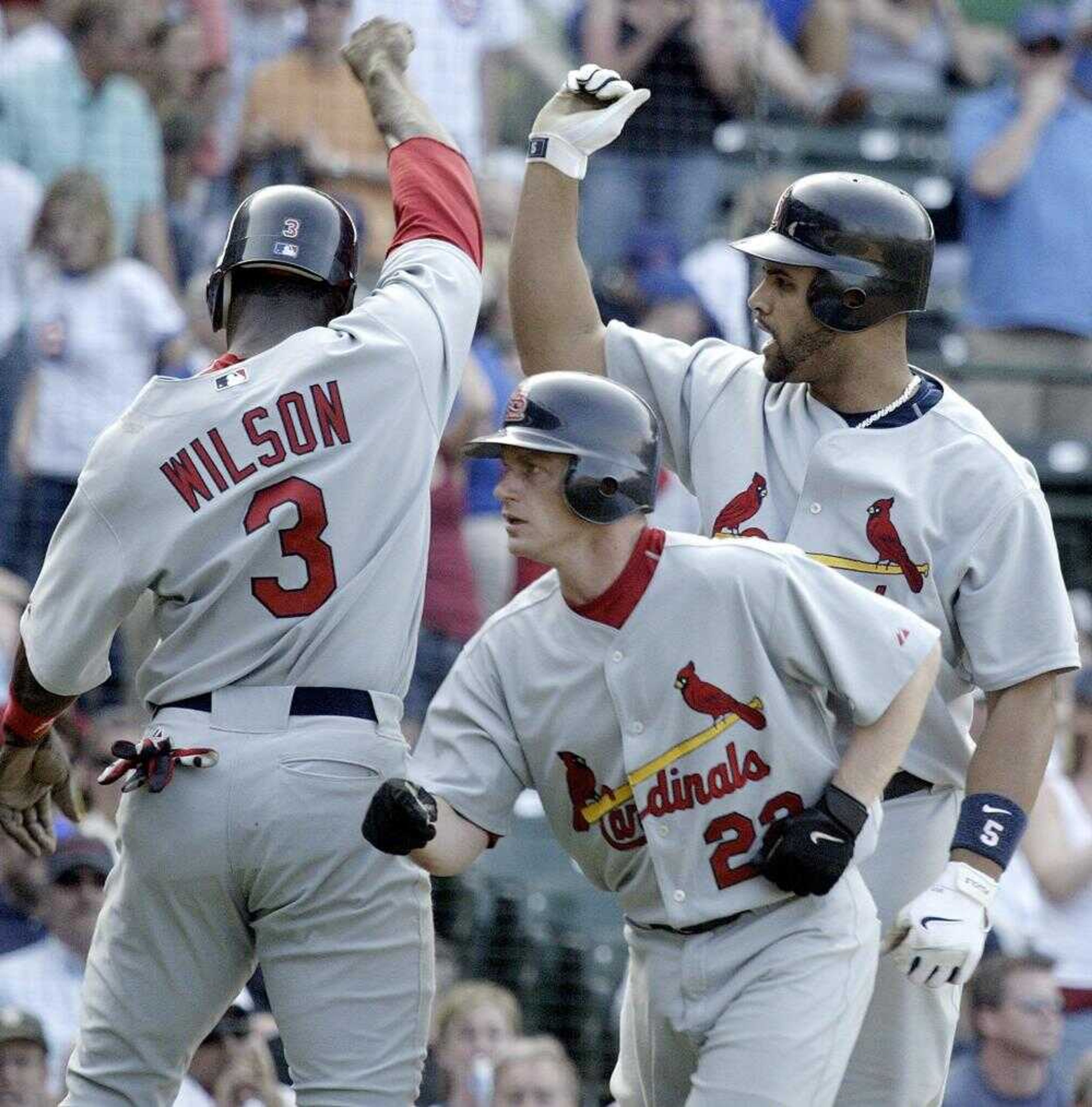 The Cardinals' Albert Pujols, right, celebrated with Preston Wilson and David Eckstein following his three-run homer in the 10th inning Sunday against the Chicago Cubs at Wrigley Field in Chicago. (JAMES A. FINLEY ~ Associated Press)