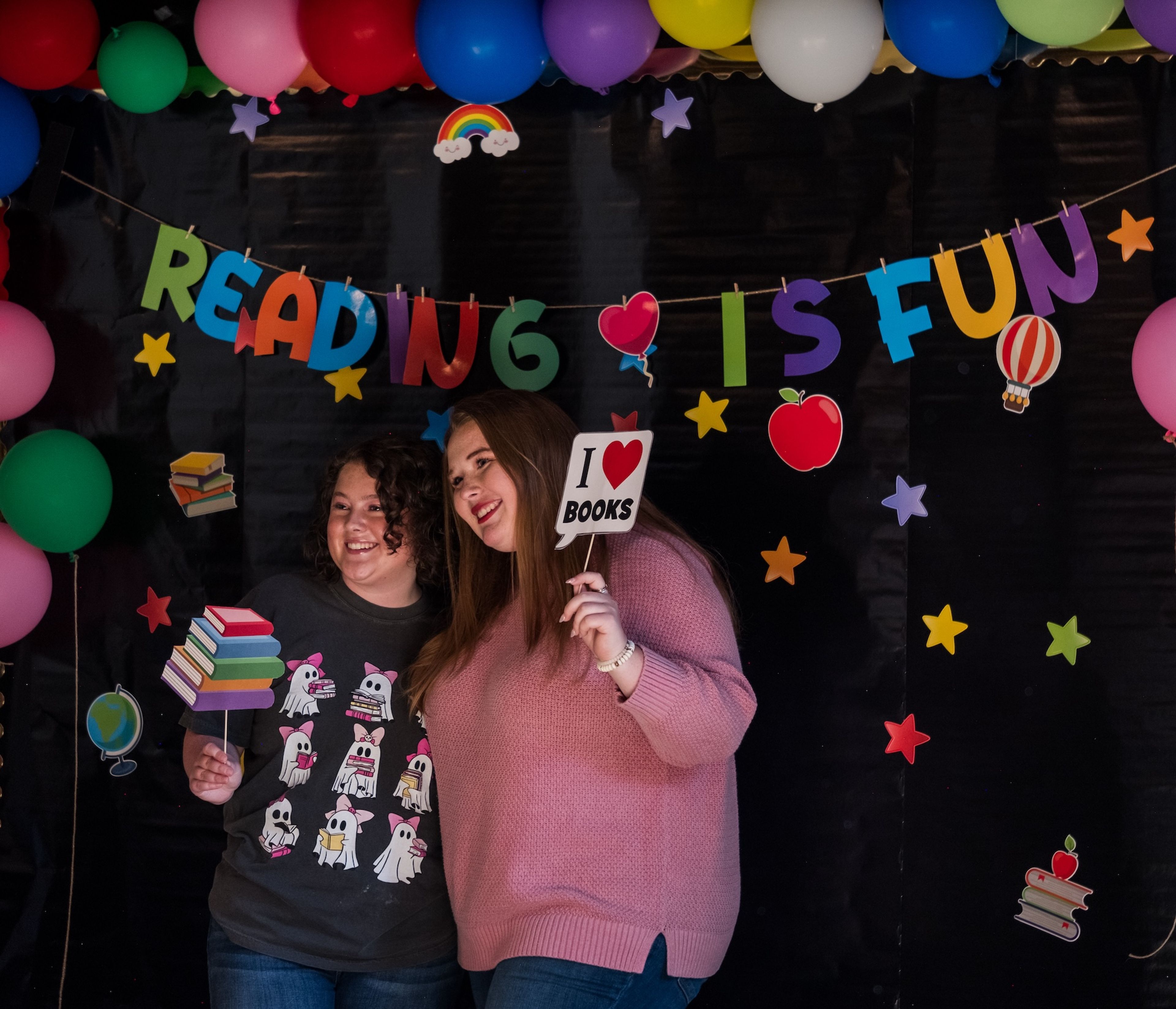 Taylor Wallace and Anna Clippard, both of Cape Girardeau, strike a pose at the Photo Booth of the Grown-Up Book Fair, which also featured a coffee bar, craft station, local art prints for sale and unique book selections from local vendors.
