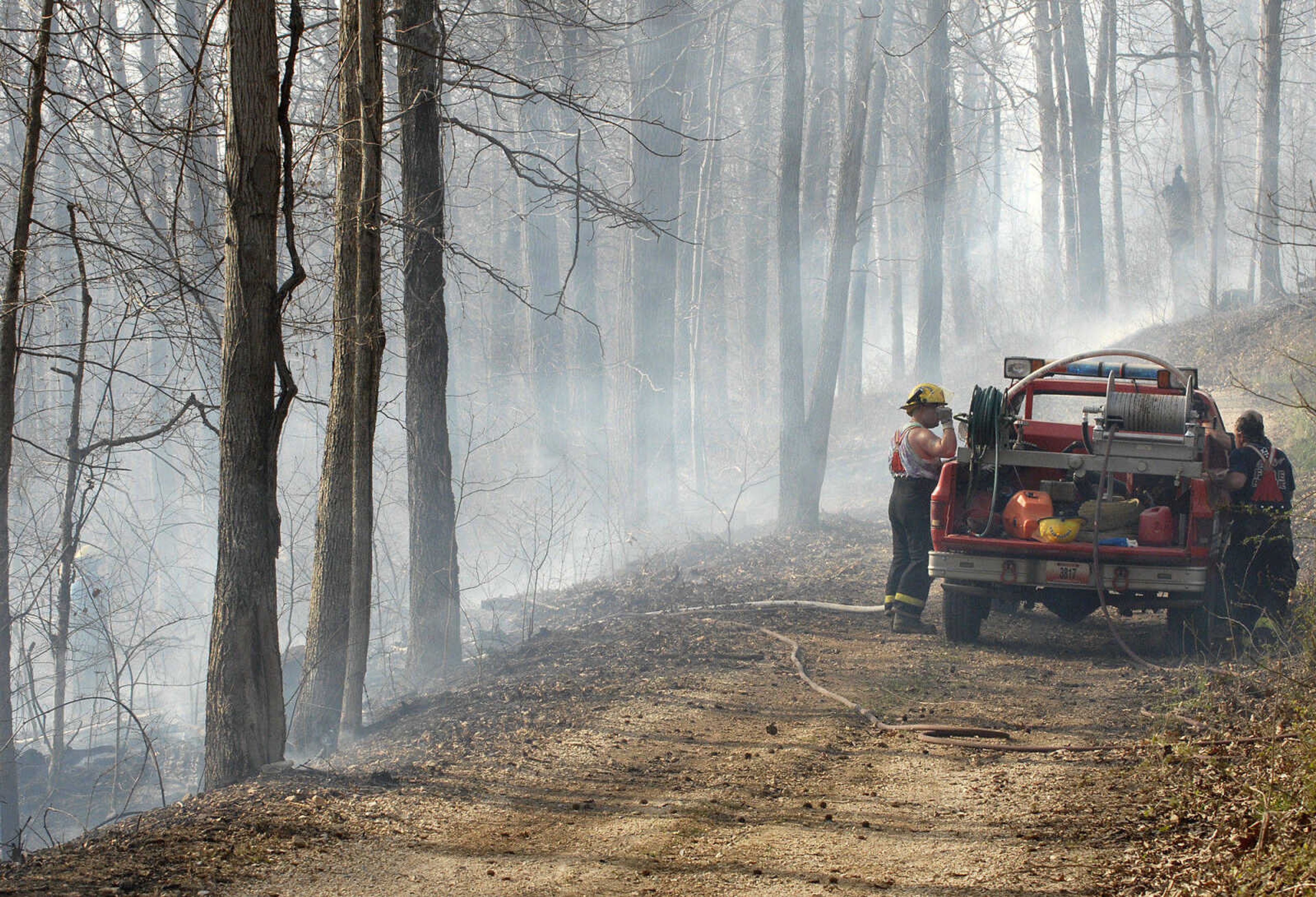 LAURA SIMON~lsimon@semissourian.com
Firefighters work to extinguish a fire on a hillside during a natural cover fire off of Cissus Lane near Neelys Landing Sunday, April 3, 2011. Firefighters from Cape Girardeau, Perry, Scott, and Bollinger Counties contained the blaze that ravaged 50 acres of land.