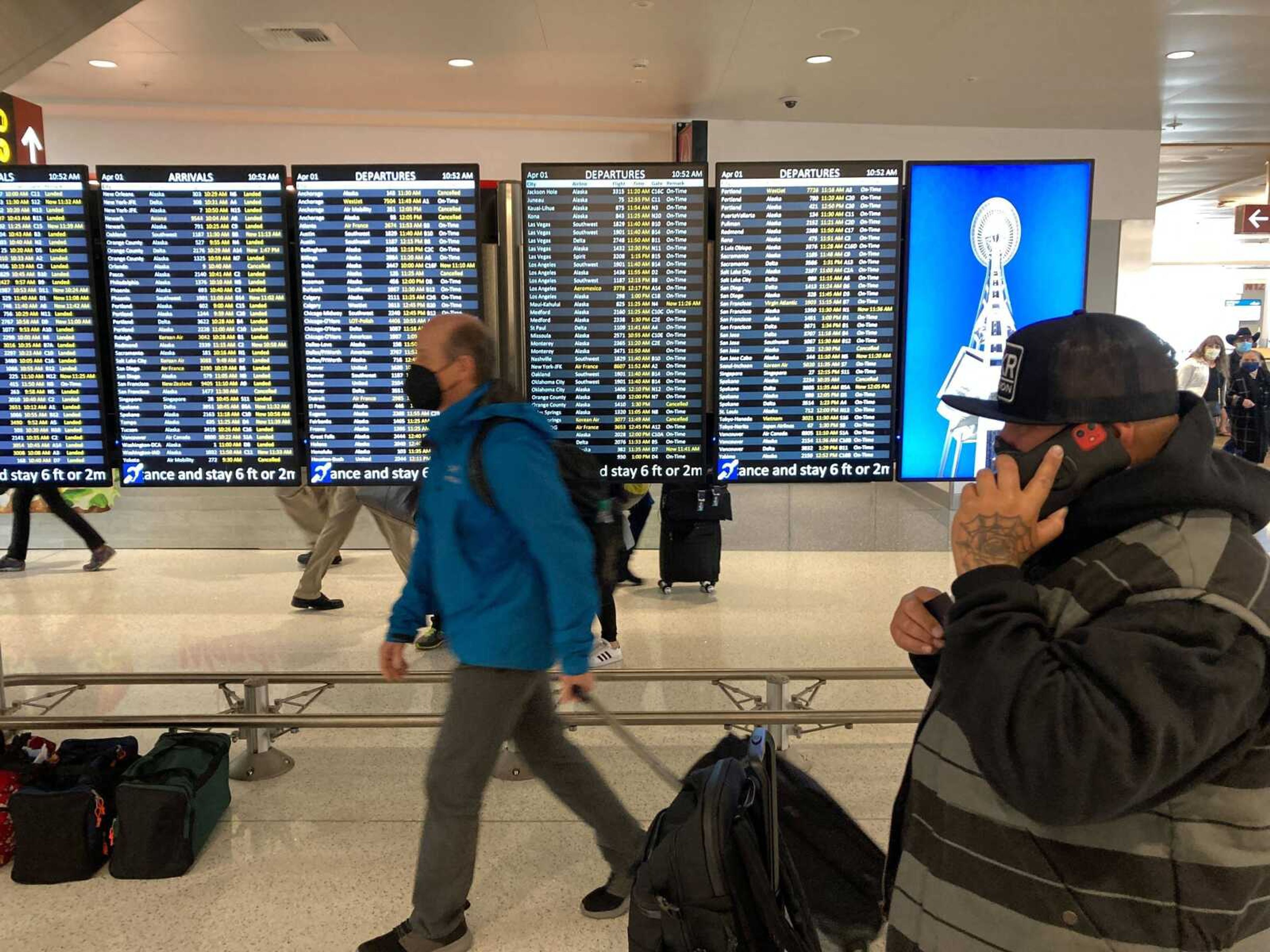 FILE - Travelers walk through Seattle-Tacoma International Airport on Friday, April 1, 2022 in Seattle. On Monday, April 18, 2022, a federal judge in Florida voided the national mask mandate covering airplanes and other public transportation saying it exceeded the authority of U.S. health officials. 