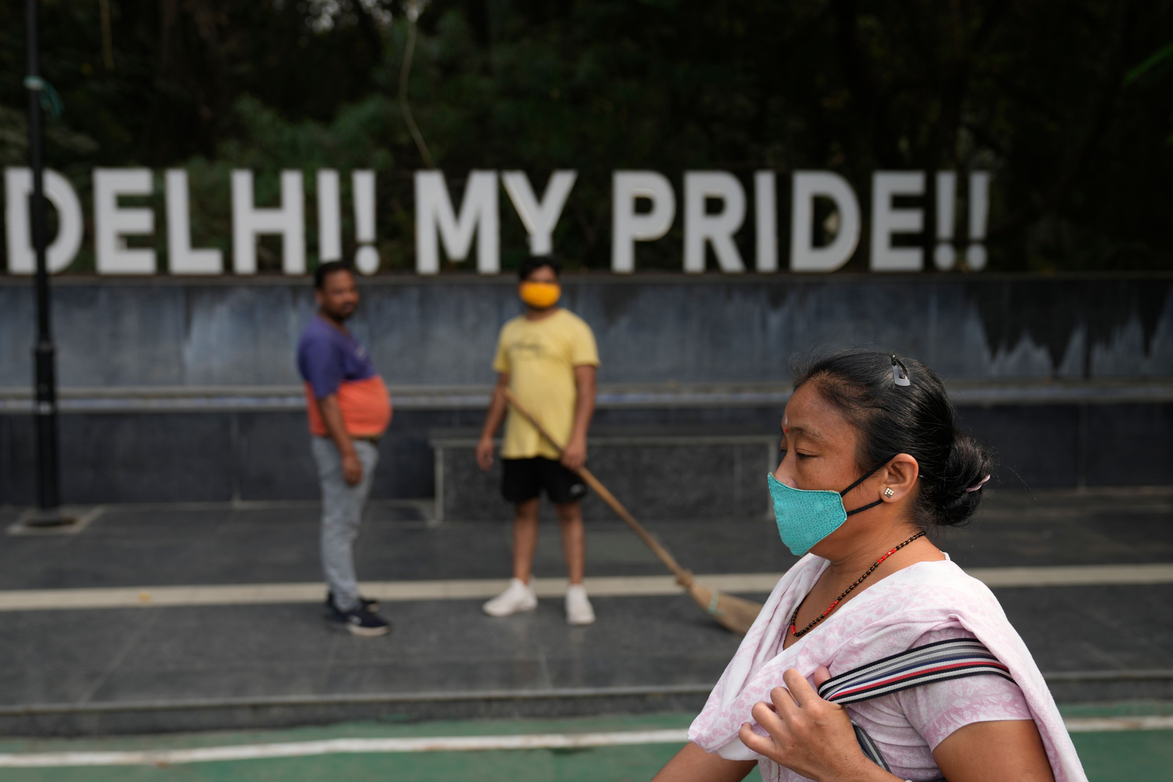 A woman wearing a face mask walks on a street in New Delhi, India, Thursday, Nov. 14, 2024. (AP Photo/Manish Swarup)