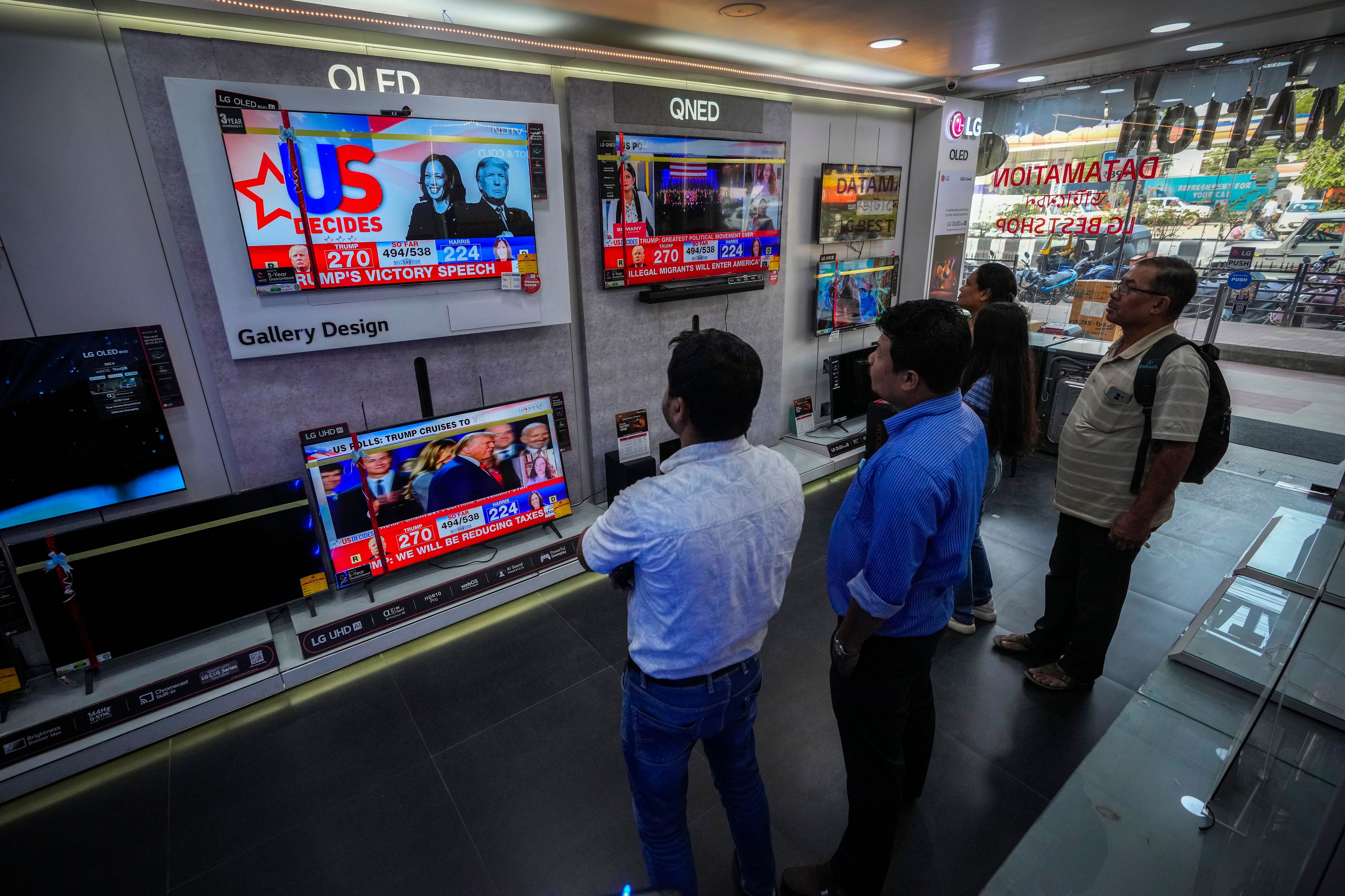 Indian people watch results of U.S. elections on a television in Guwahati, India, Wednesday, Nov. 6, 2024. (AP Photo/Anupam Nath)