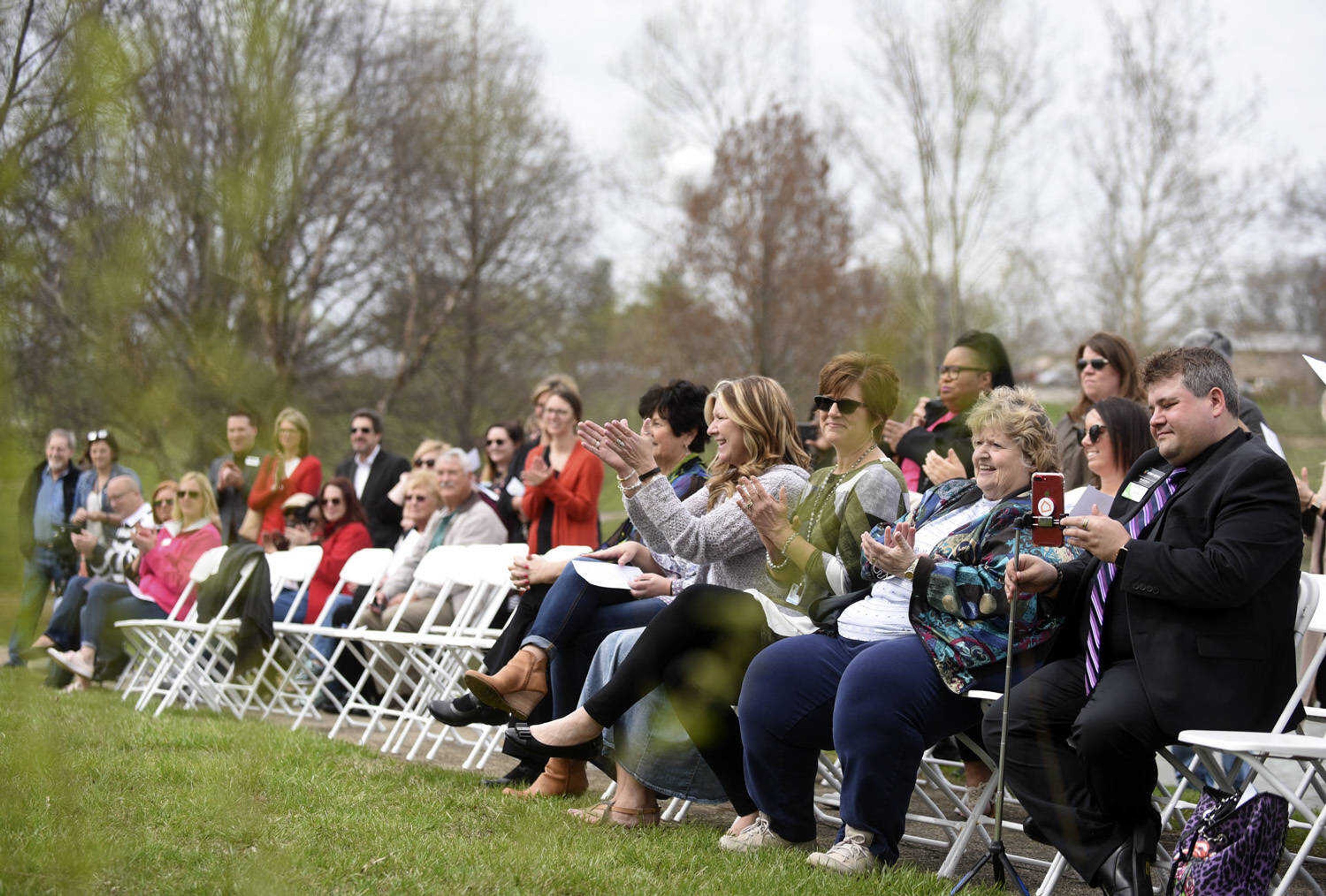 Community members applaud at Cape County Park North for a symbolic ground-breaking ceremony for the new women's safe house on Friday, April 6, 2018, in Cape Girardeau.