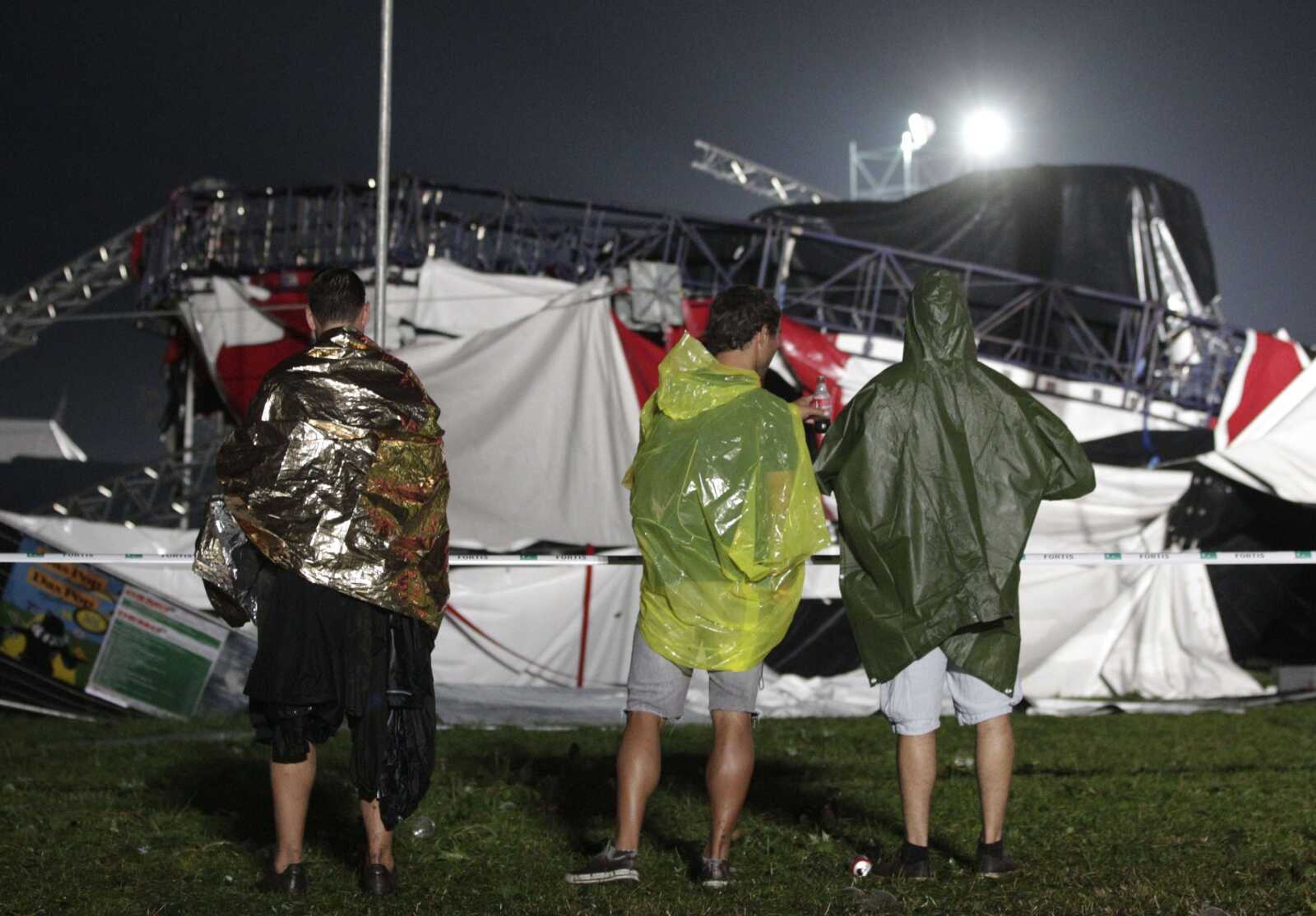 Music fans look at a collapsed festival tent Thursday after a storm swept through an open-air music festival near Hasselt, Belgium, about 50 miles east of Brussels. The storm killed at least three people and injured more than 70 others, an official said. (Yves Logghe ~ Associated Press)