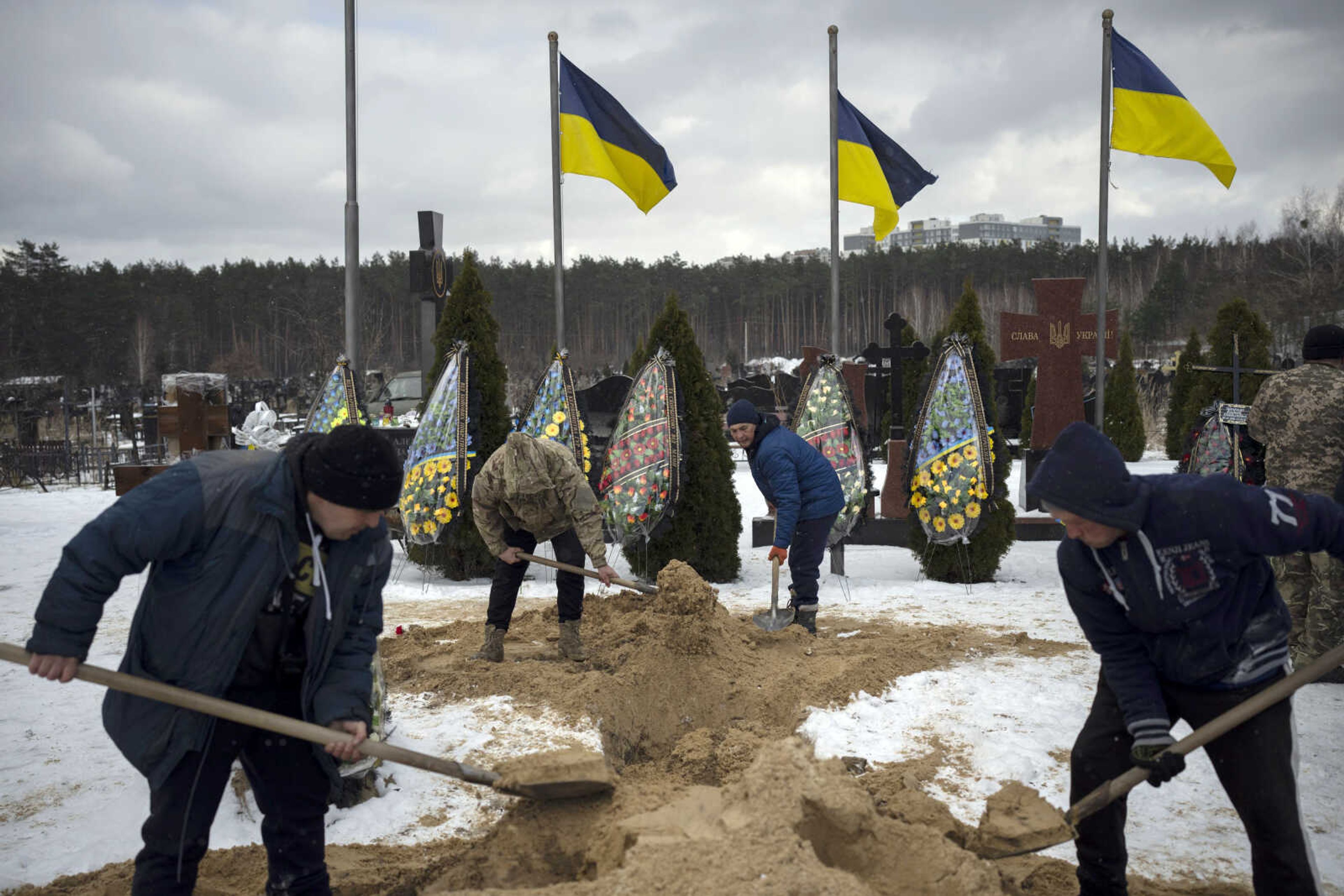 Undertakers bury the coffin of Eduard Strauss during his funeral Monday in Irpin, Ukraine.