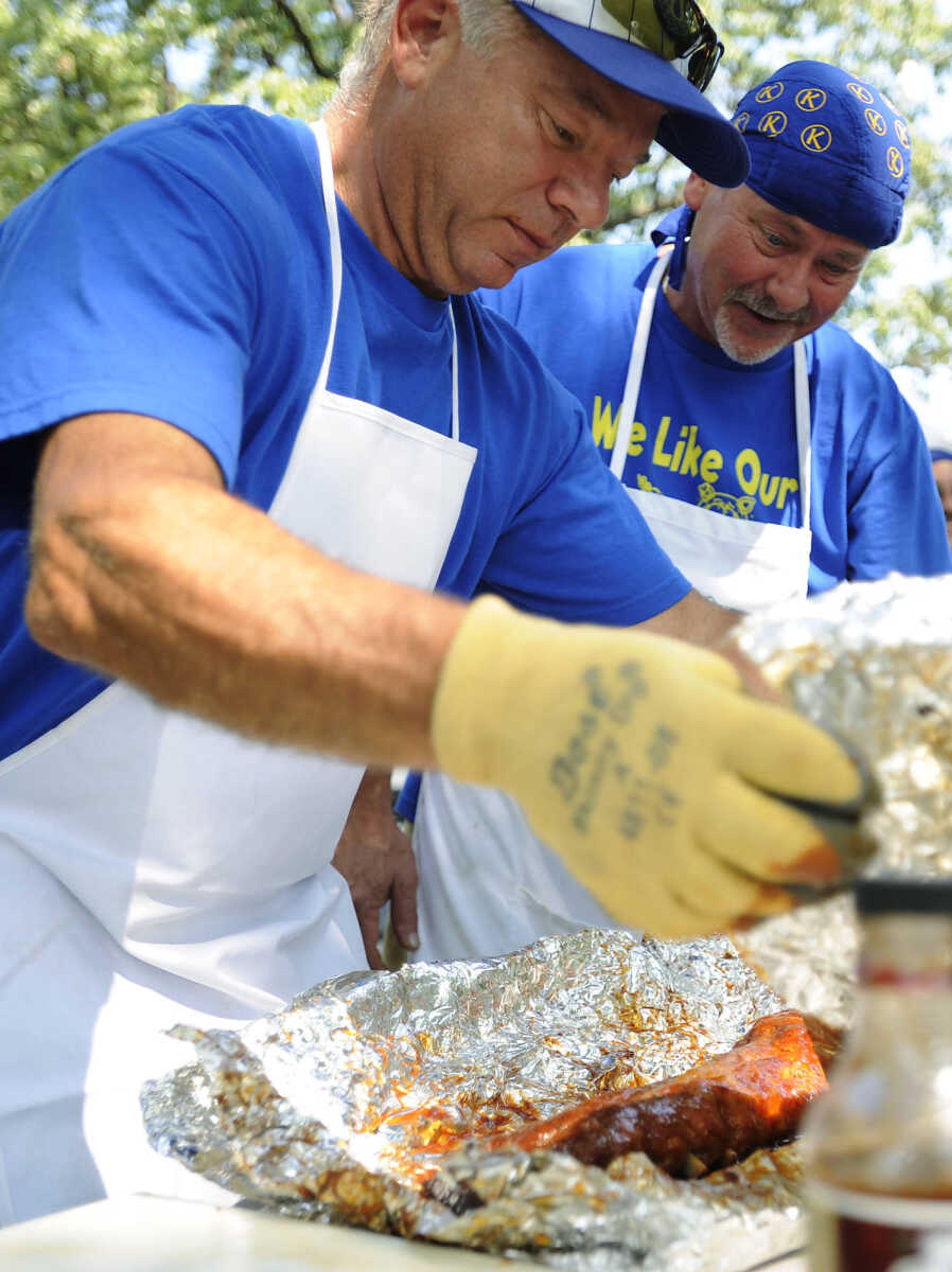 Fred Ducharme, left, and Chris Adkisson work on the Kiwanis Club team's rib entry during the 21st annual Cape BBQ Fest Saturday, Aug. 24, at Arena Park in Cape Girardeau. The Kiwanis Club team was one of fifty-seven teams competed in the event which is sanctioned by the Kansas City Barbecue Society and sponsored by the Jaycees.