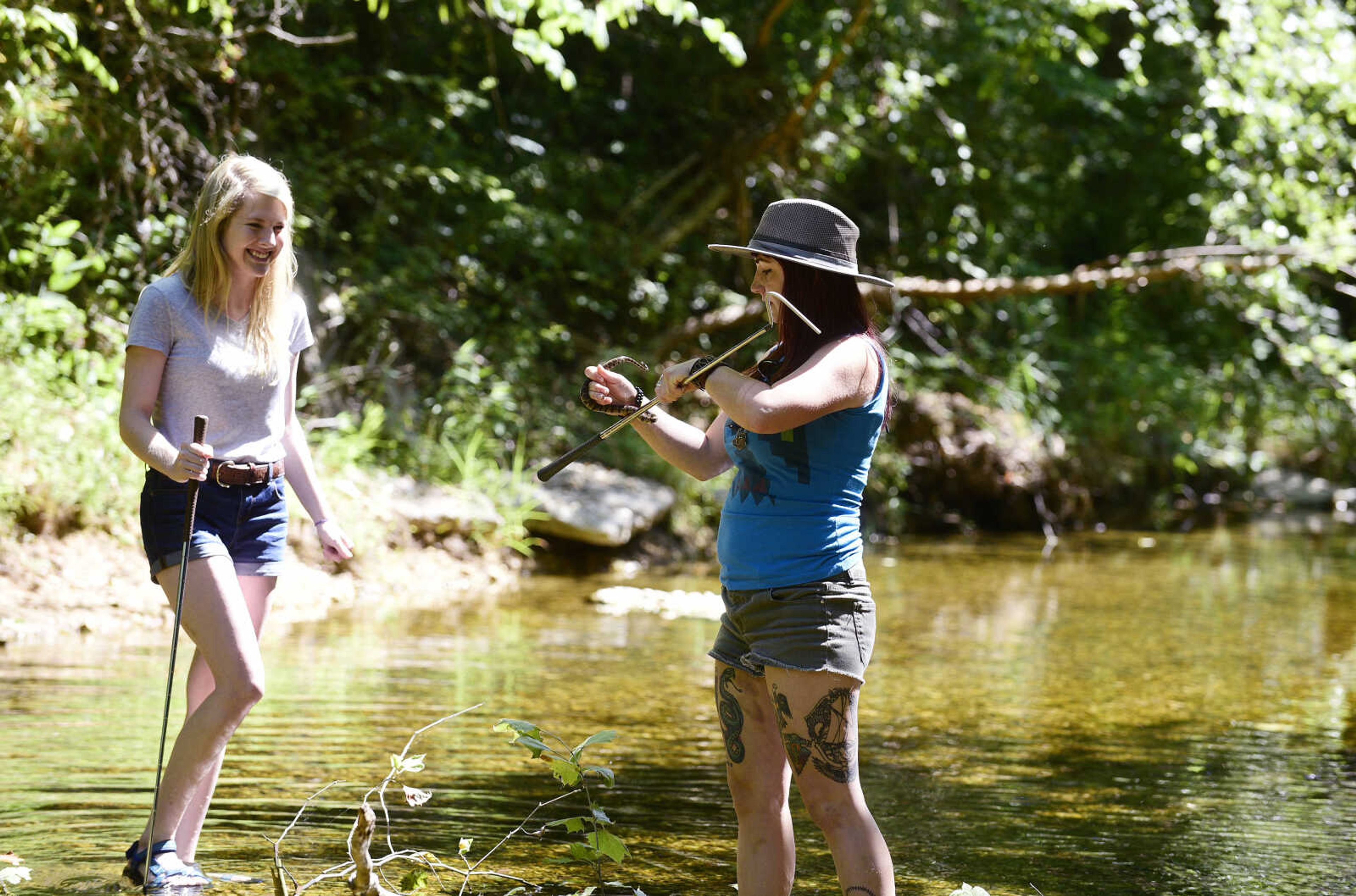 Jordyn Richmond, left, and Anna Mae Zembsch find a small Northern Water Snake in Little Indian Creek near Oriole, Missouri.