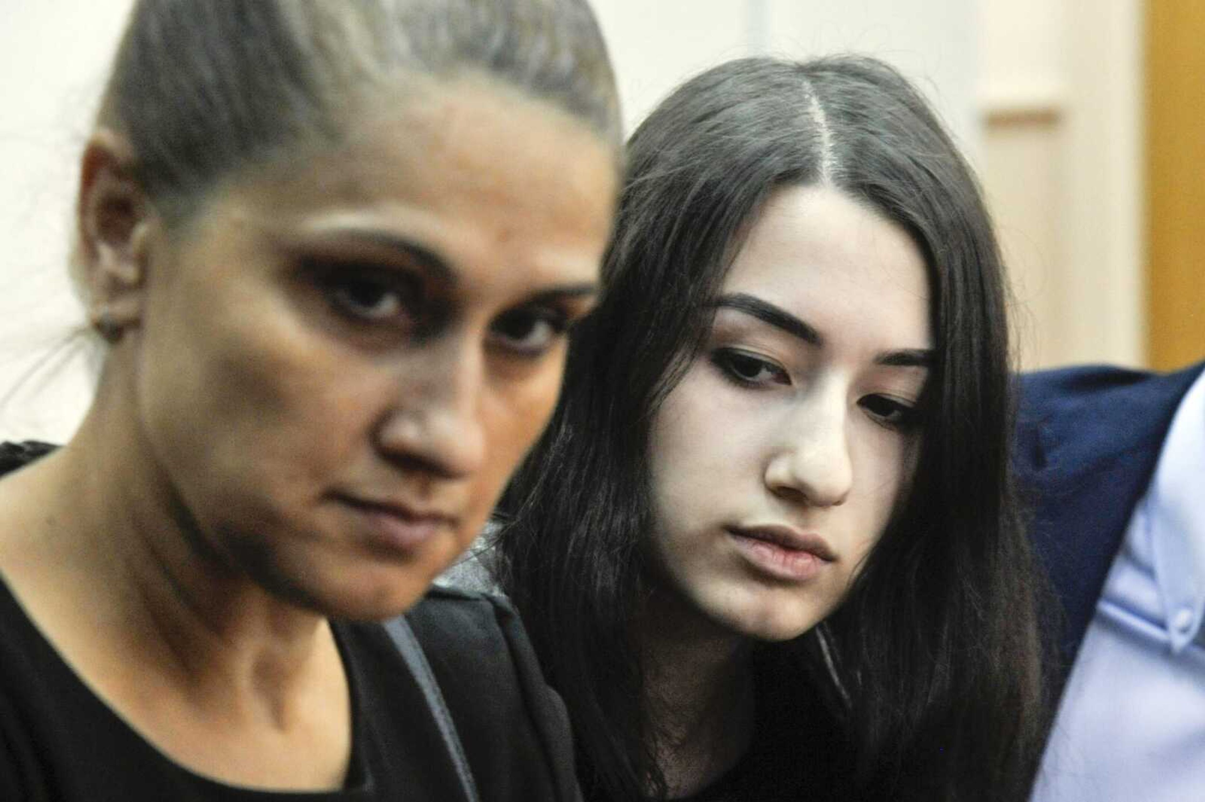 Krestina Khachaturyan, right, and her mother, Aurelia Dunduk, attend hearings in a courtroom in Moscow. Three Khachaturyan sisters face charges of the premeditated murder of their father, who allegedly abused them for years.