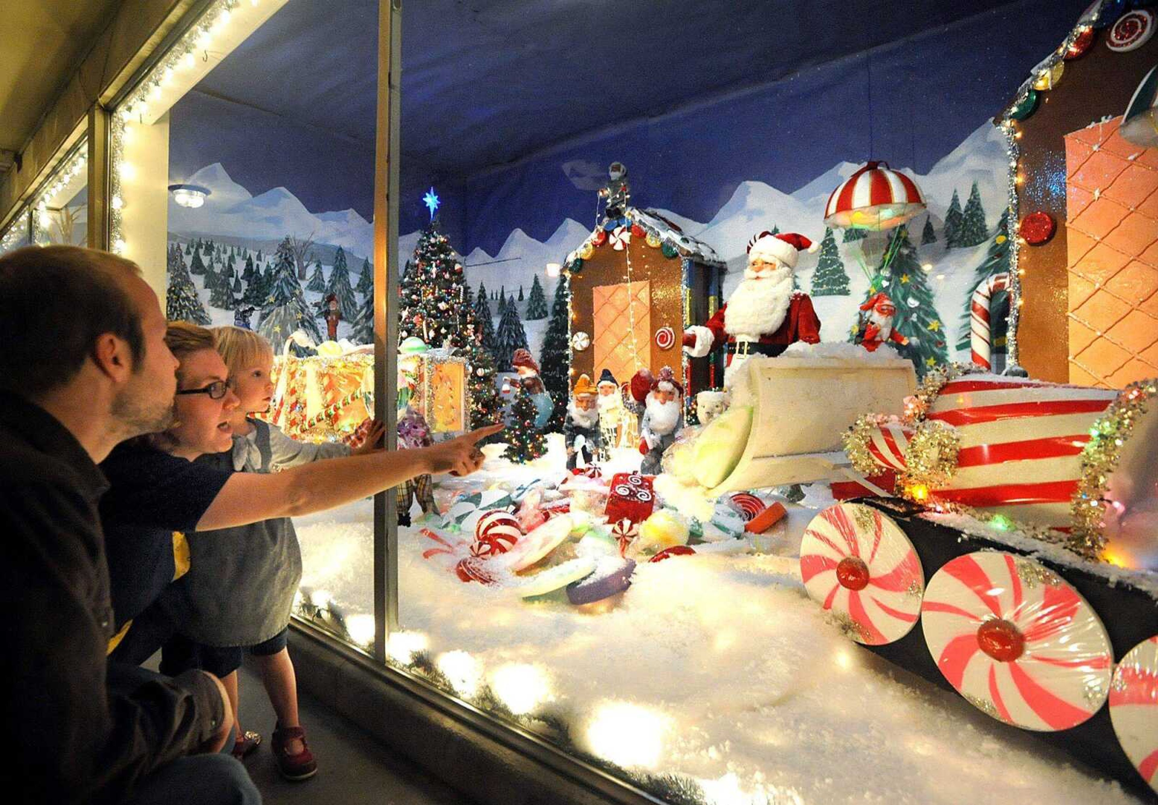 Nathan and Melissa Tenholder of St. Louis show their daughter Violet, 2, the Christmas display in the window of Hutson&#8217;s Fine Furniture on Thursday evening in downtown Cape Girardeau. The annual display has been revealed the night of Thanksgiving each year since 1960. (Laura Simon)