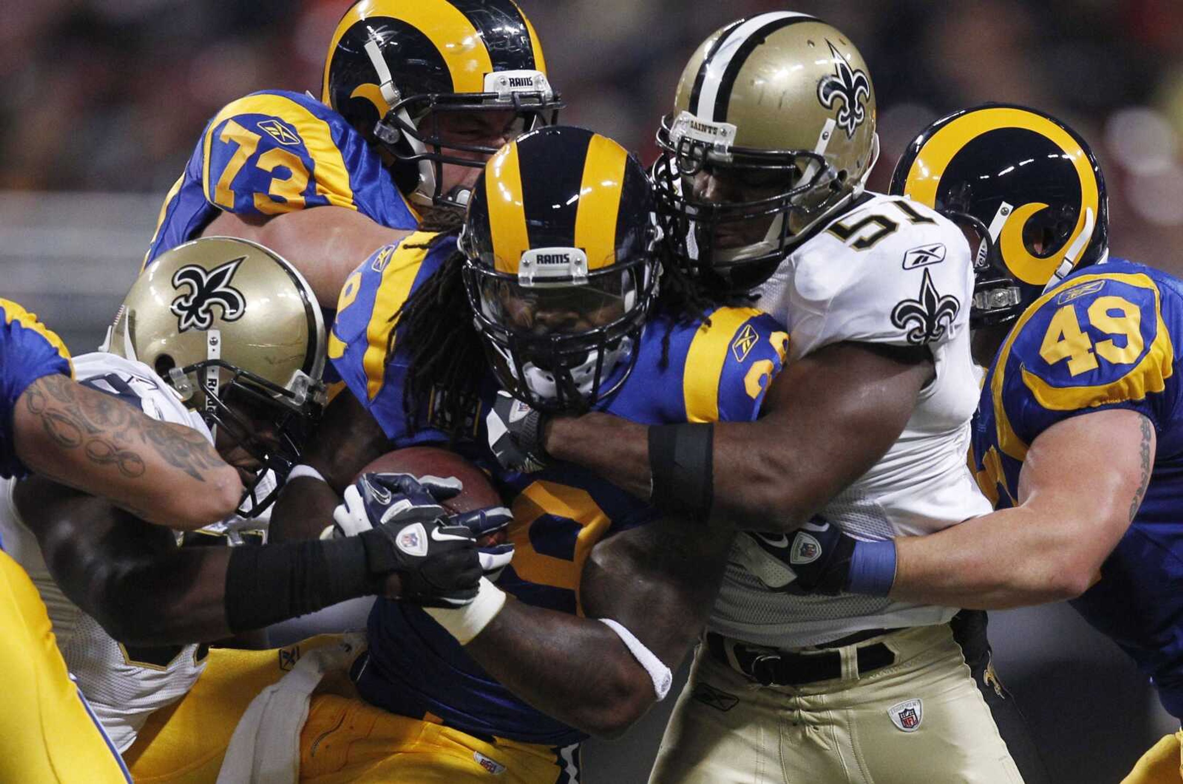 Rams running back Steven Jackson, center, is tackled by Saints linebacker Jo-Lonn Dunbar, left, and linebacker Jonathan Vilma during the first quarter of their game last week in St. Louis. (JEFF ROBERSON ~ Associated Press)