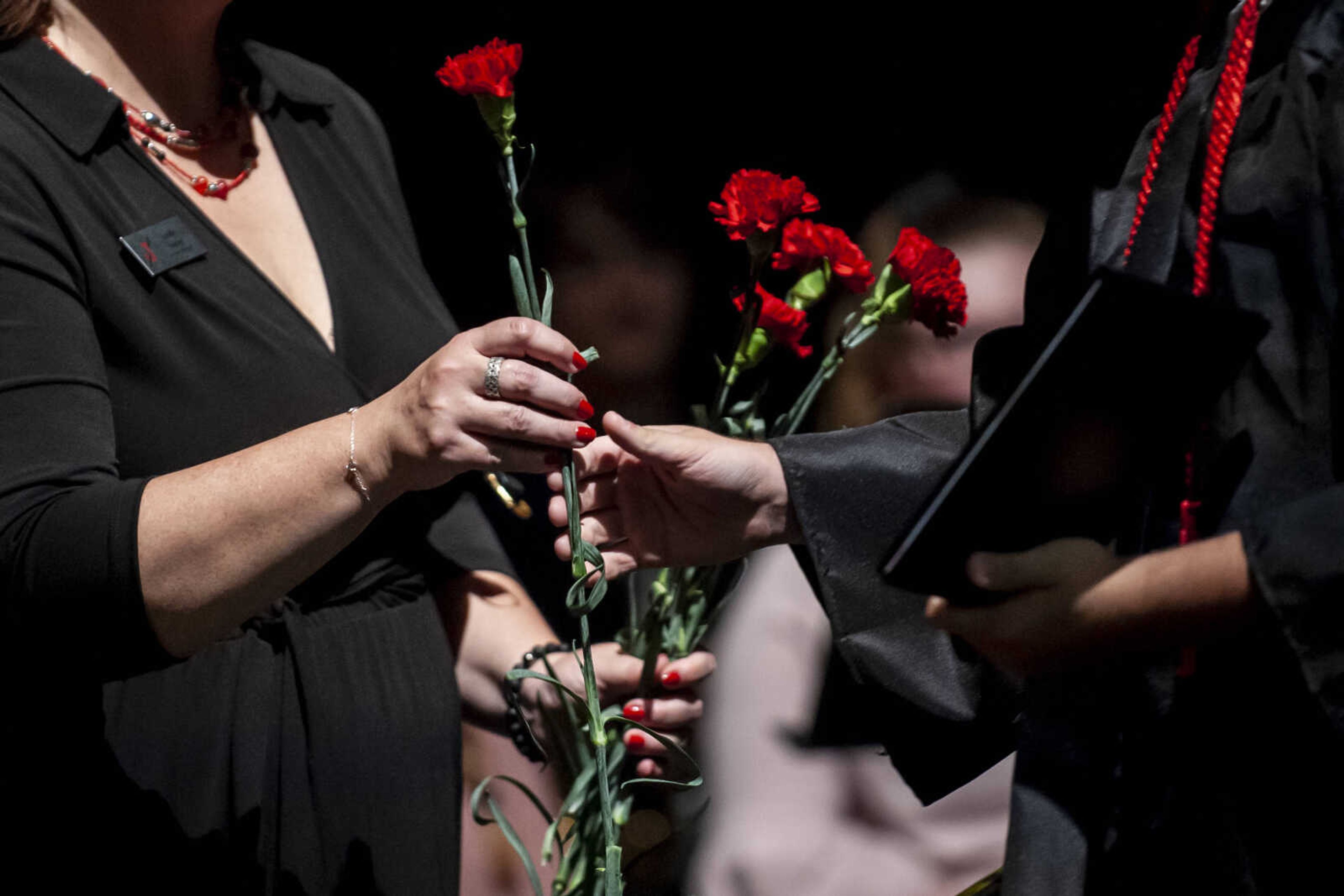 Graduates receive red carnations after walking across the stage to receive their diplomas during the Jackson High School Class of 2019 Commencement at the Show Me Center Friday, May 24, 2019, in Cape Girardeau.