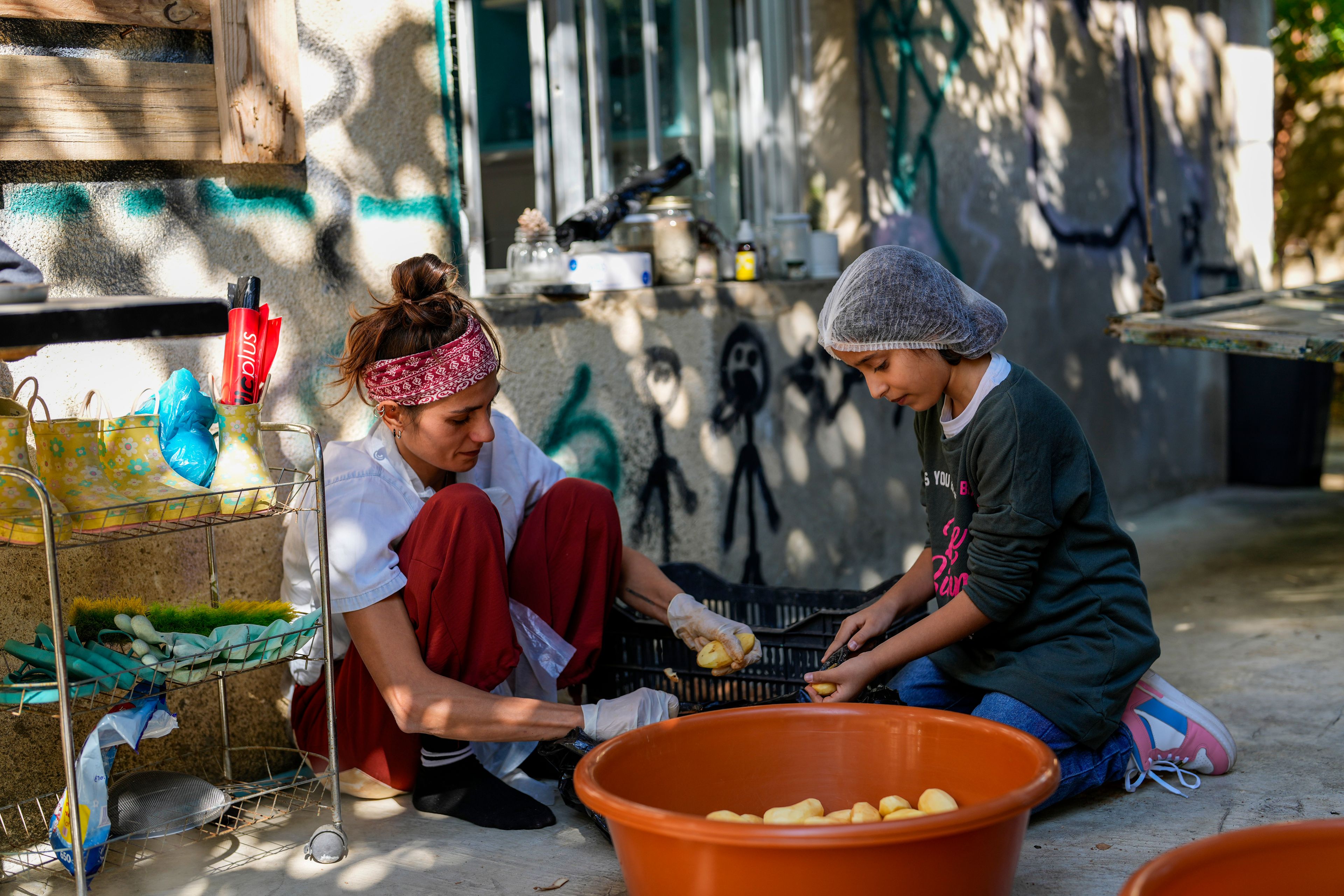 Volunteers prepare meals at a women's art center that was turned into a kitchen for displaced people who fled southern Lebanon amid the ongoing Hezbollah-Israel war, in the town of Aqaibe, northern Lebanon, Thursday, Oct. 24, 2024. (AP Photo/Hassan Ammar)