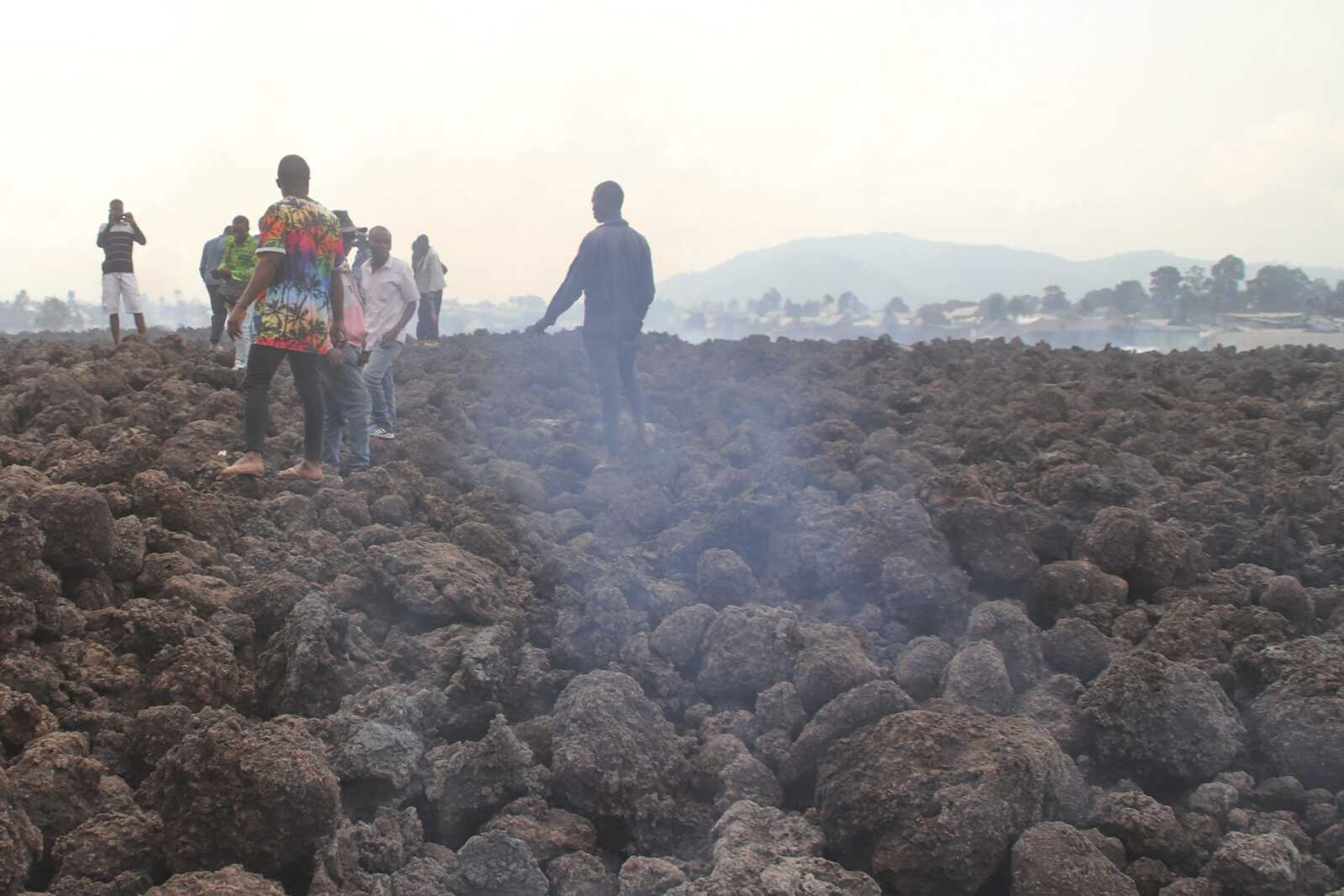 People gather on a stream of cold lava rock Sunday following the overnight eruption of Mount Nyiragongo in Goma, Congo.