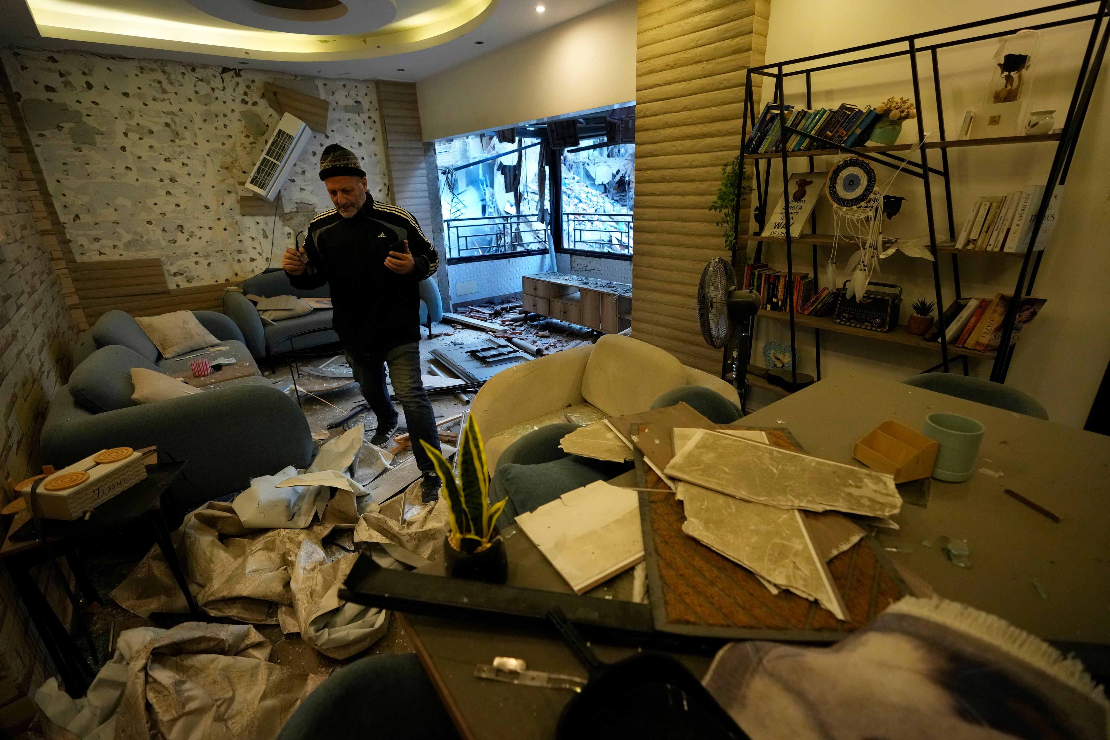 A man checks his damaged apartment which was resulted from Sunday's Israeli airstrike in Dahiyeh, in the southern suburb of Beirut, Lebanon, Monday, Nov. 25, 2024. (AP Photo/Hussein Malla)