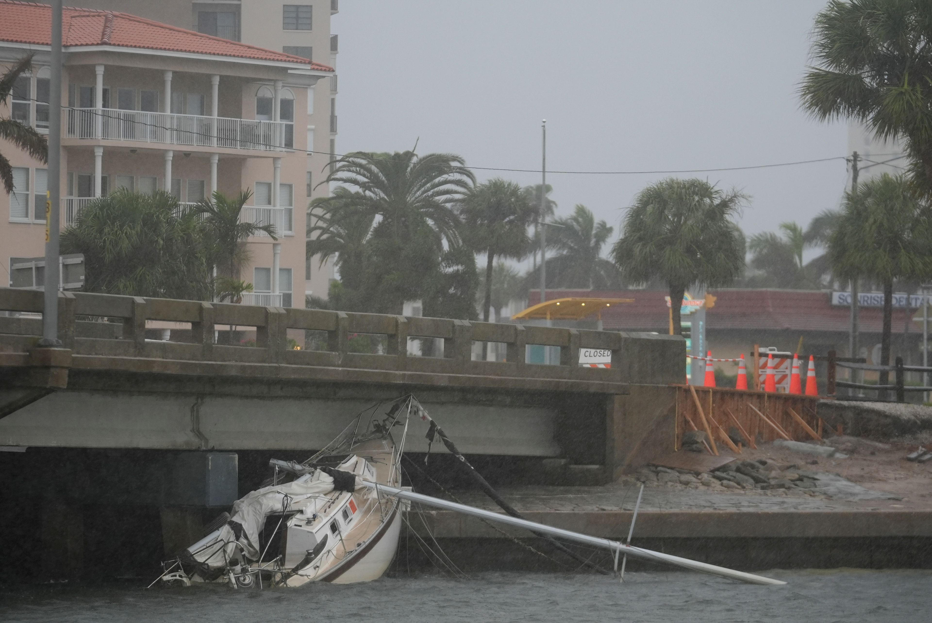 A boat damaged in Hurricane Helene rests against a bridge ahead of the arrival of Hurricane Milton, in South Pasadena, Fla., Wednesday, Oct. 9, 2024. (AP Photo/Rebecca Blackwell)