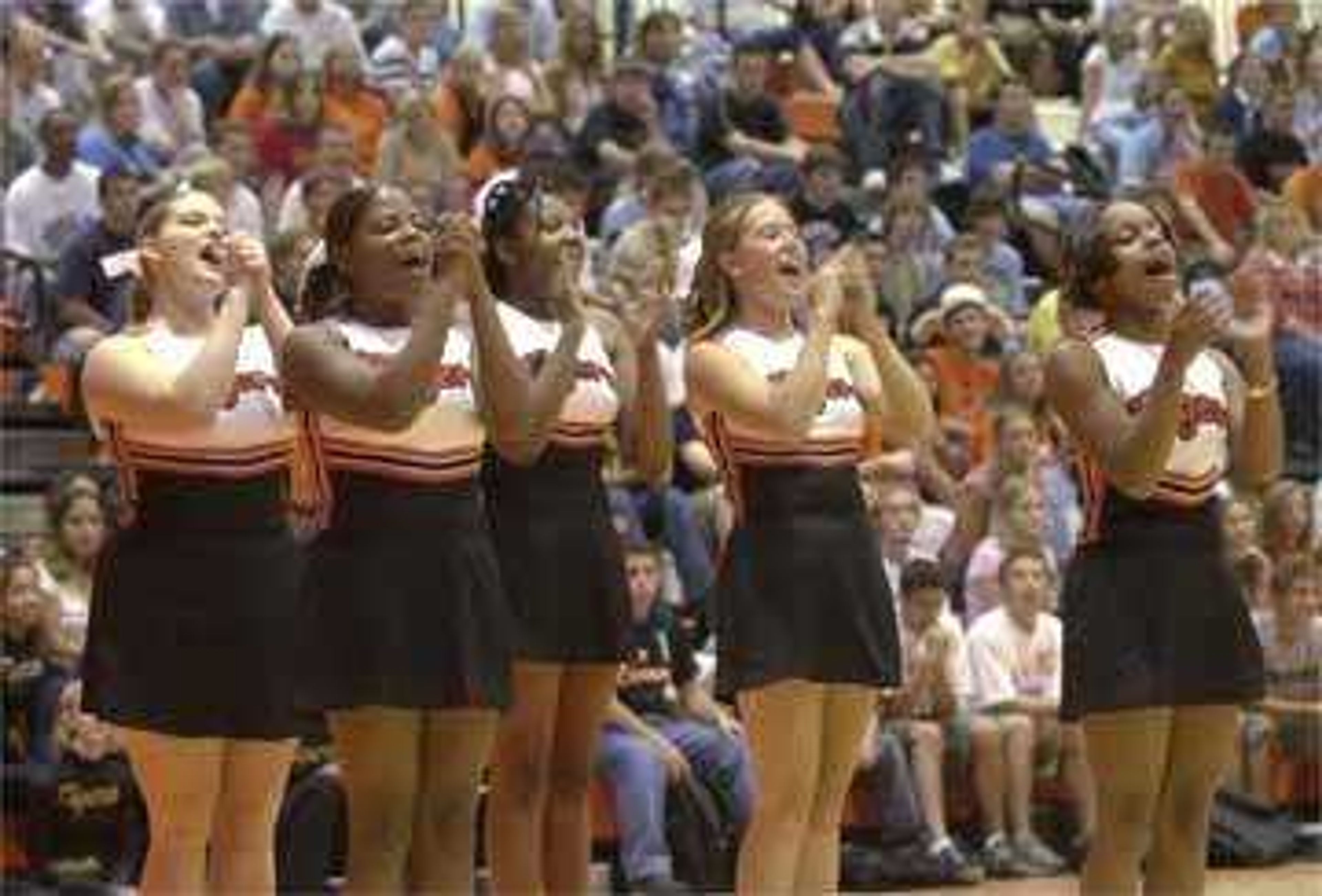 Central High School soccer-wrestling cheerleaders yell with fellow students in the field house.