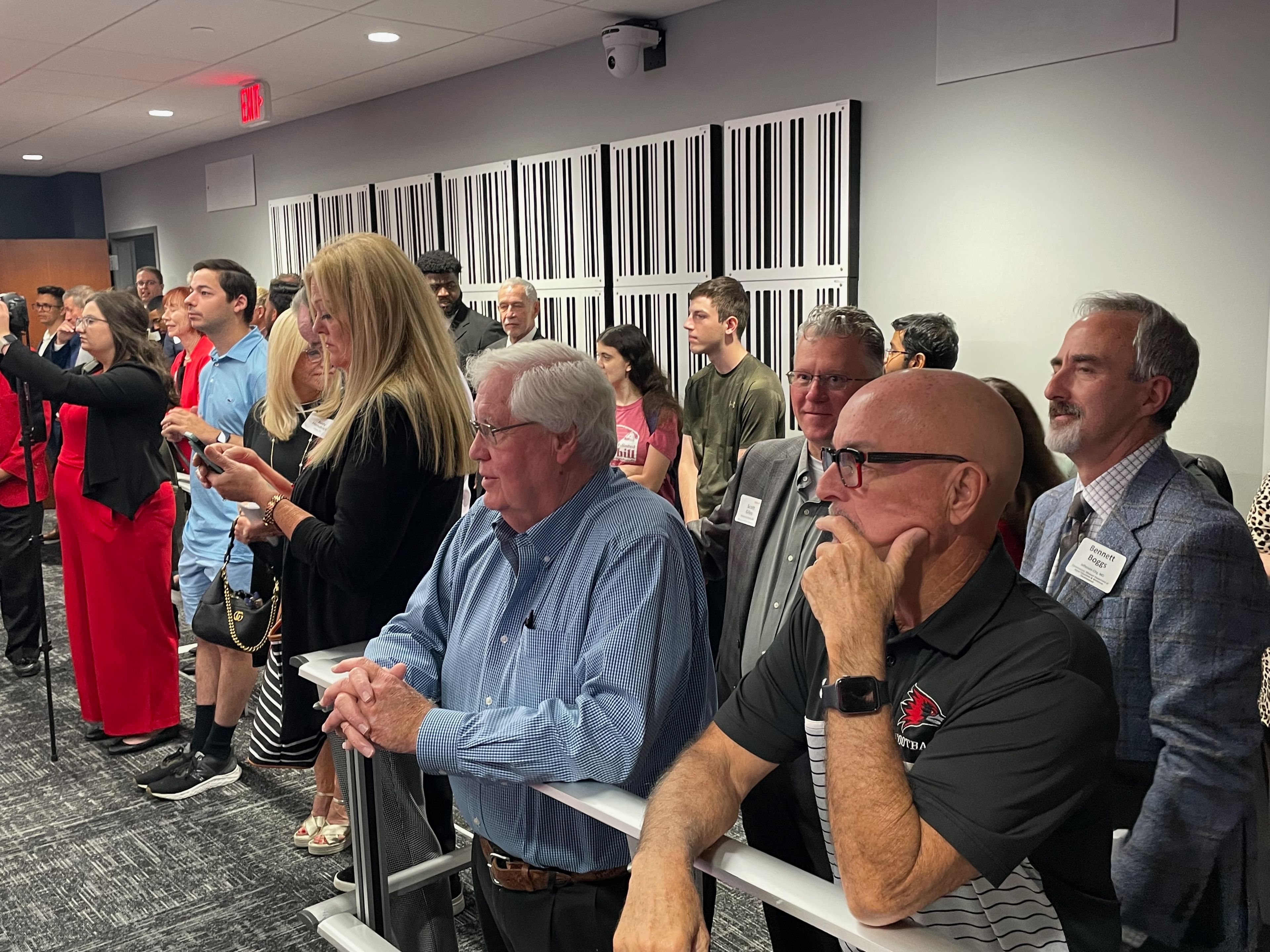 Guests of the ribbon cutting watch as the SEMO Cyber Defense team prepares to take action. In front center and front right are members of the university's board of governors Lloyd Smith and Jim Limbaugh, respectively.