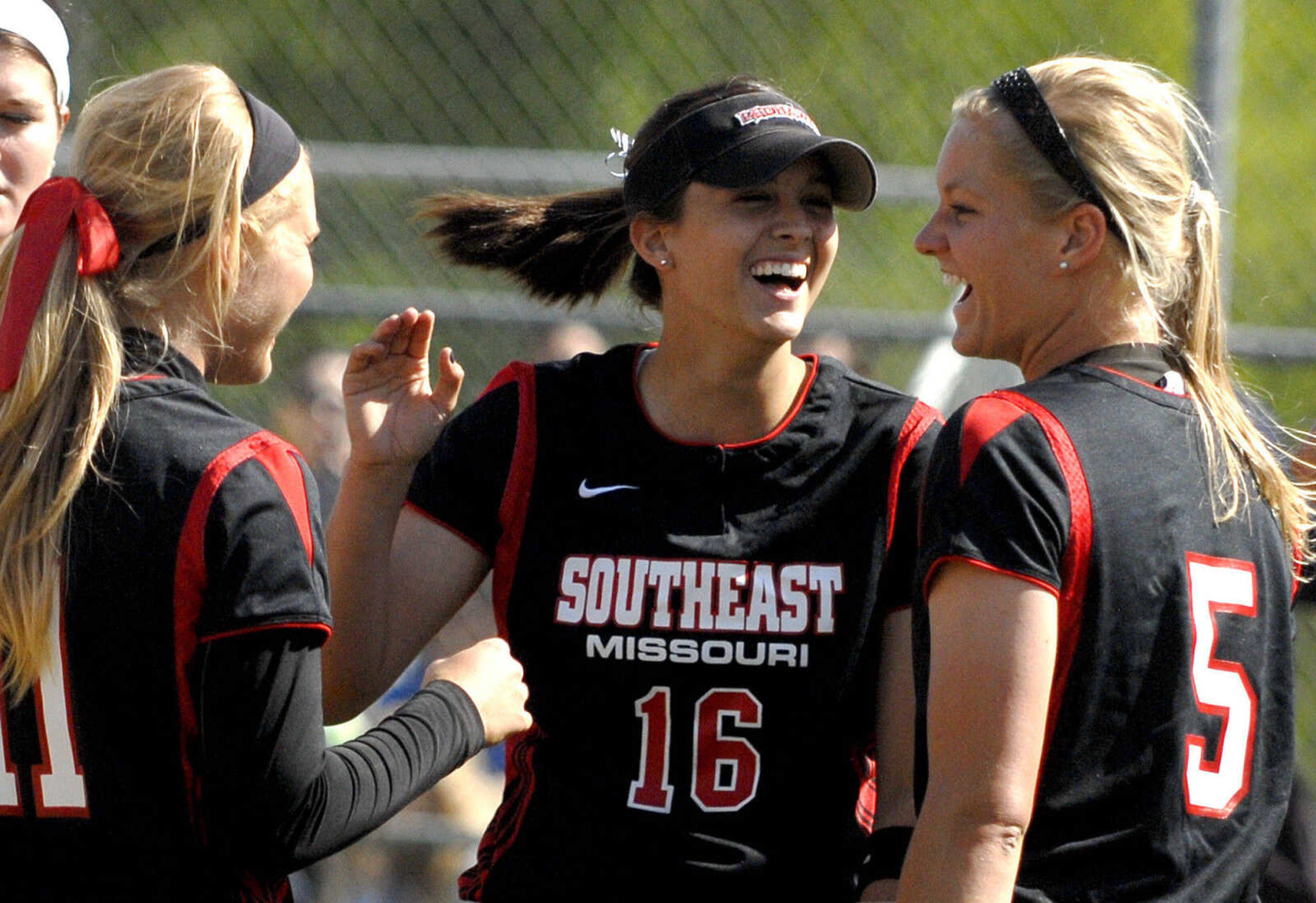 LAURA SIMON~lsimon@semissourian.com
Southeast players Kaitlin Wallace, left, and Renee Kertz, right, congratulate pitcher Alora Marble on another scoreless inning in the fifth inning during the first game of a double-header against Saint Louis University Wednesday, May 4, 2011 at the Southeast Softball Complex.