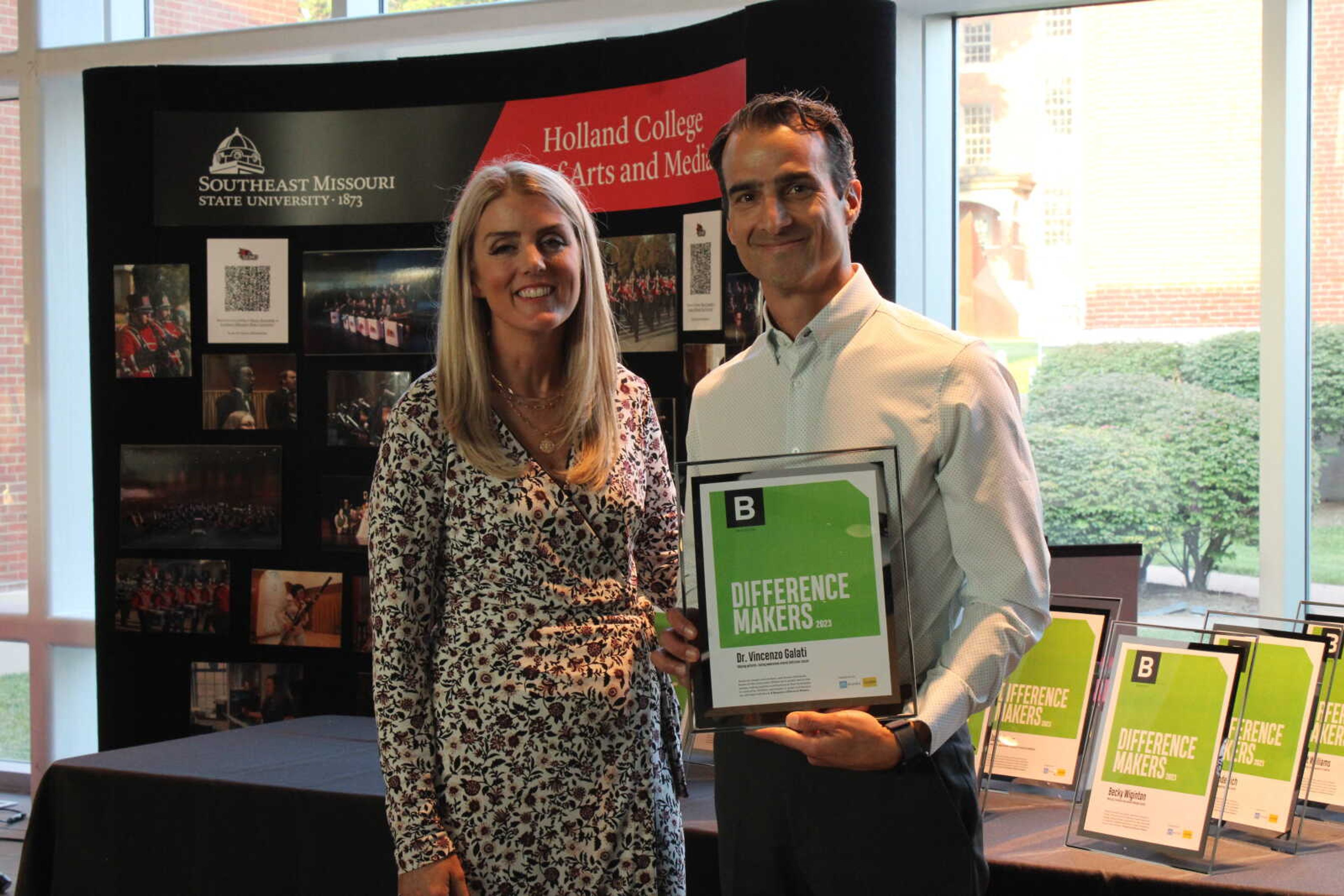 Edward Jones financial advisor Brooke Roth hands Difference Maker Dr. Vincenzo Galati his award.