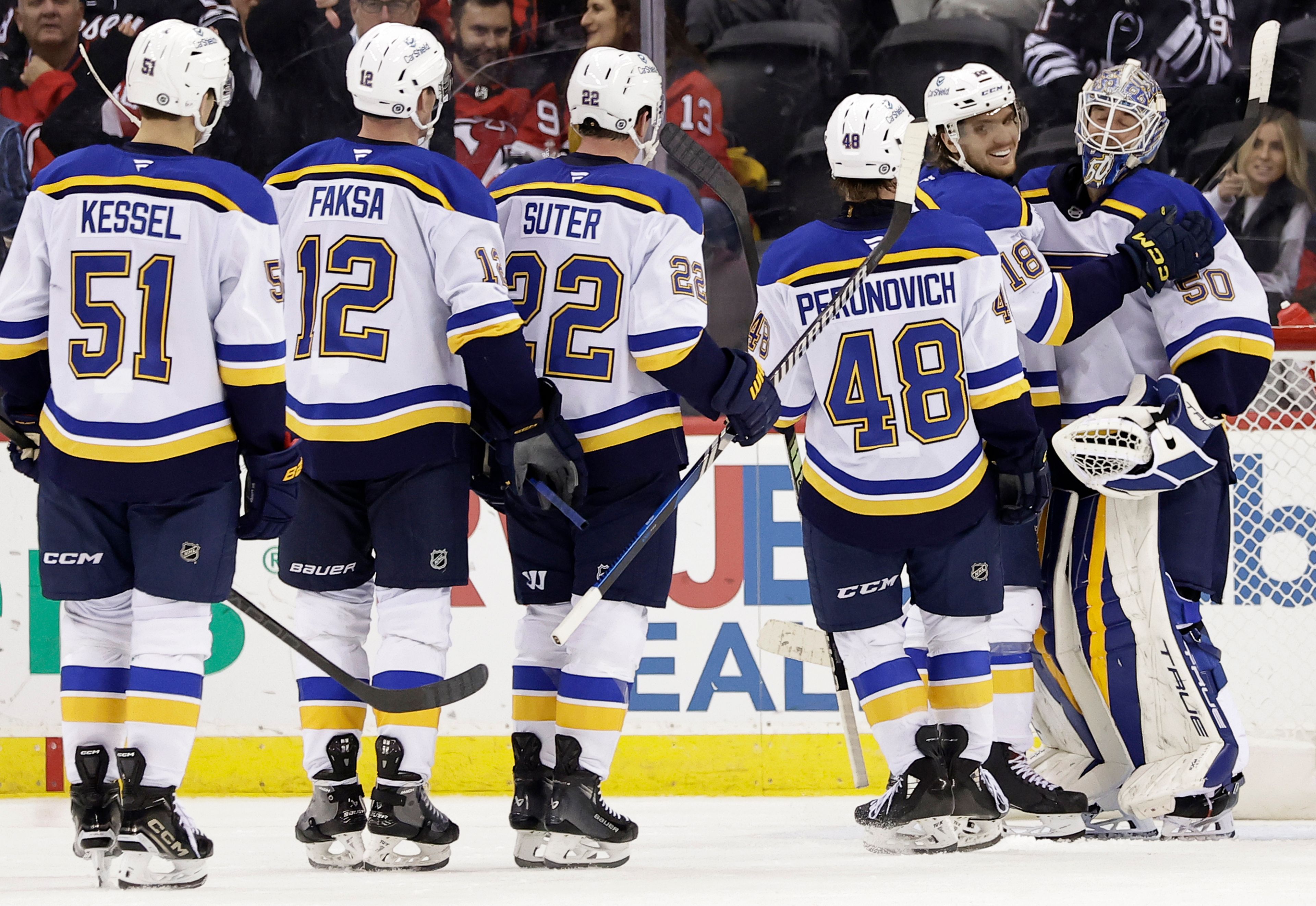 St. Louis Blues goaltender Jordan Binnington is congratulated by Robert Thomas (18) after the Blues defeated the New Jersey Devils 3-0 in an NHL hockey game Wednesday, Nov. 27, 2024, in Newark, N.J. (AP Photo/Adam Hunger)