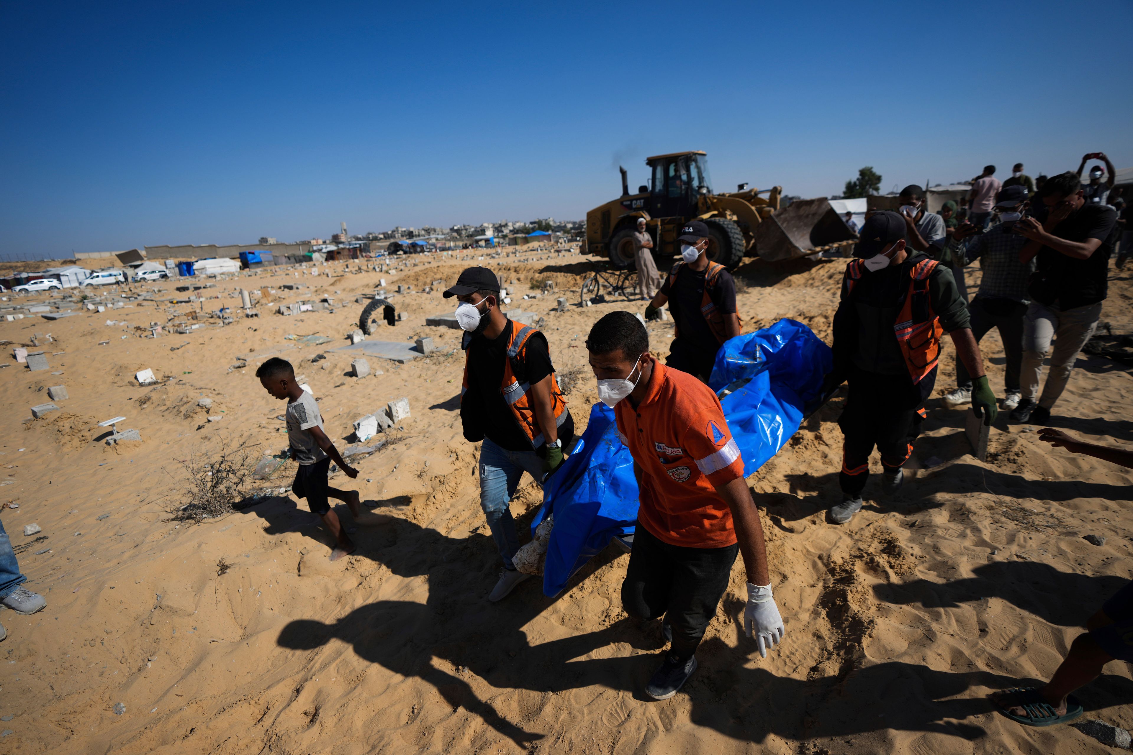 People bury the bodies of Palestinians taken by the Israeli military during operations in Gaza and returned this week, in Khan Younis, Gaza Strip, Thursday, Sept. 26, 2024. (AP Photo/Abdel Kareem Hana)