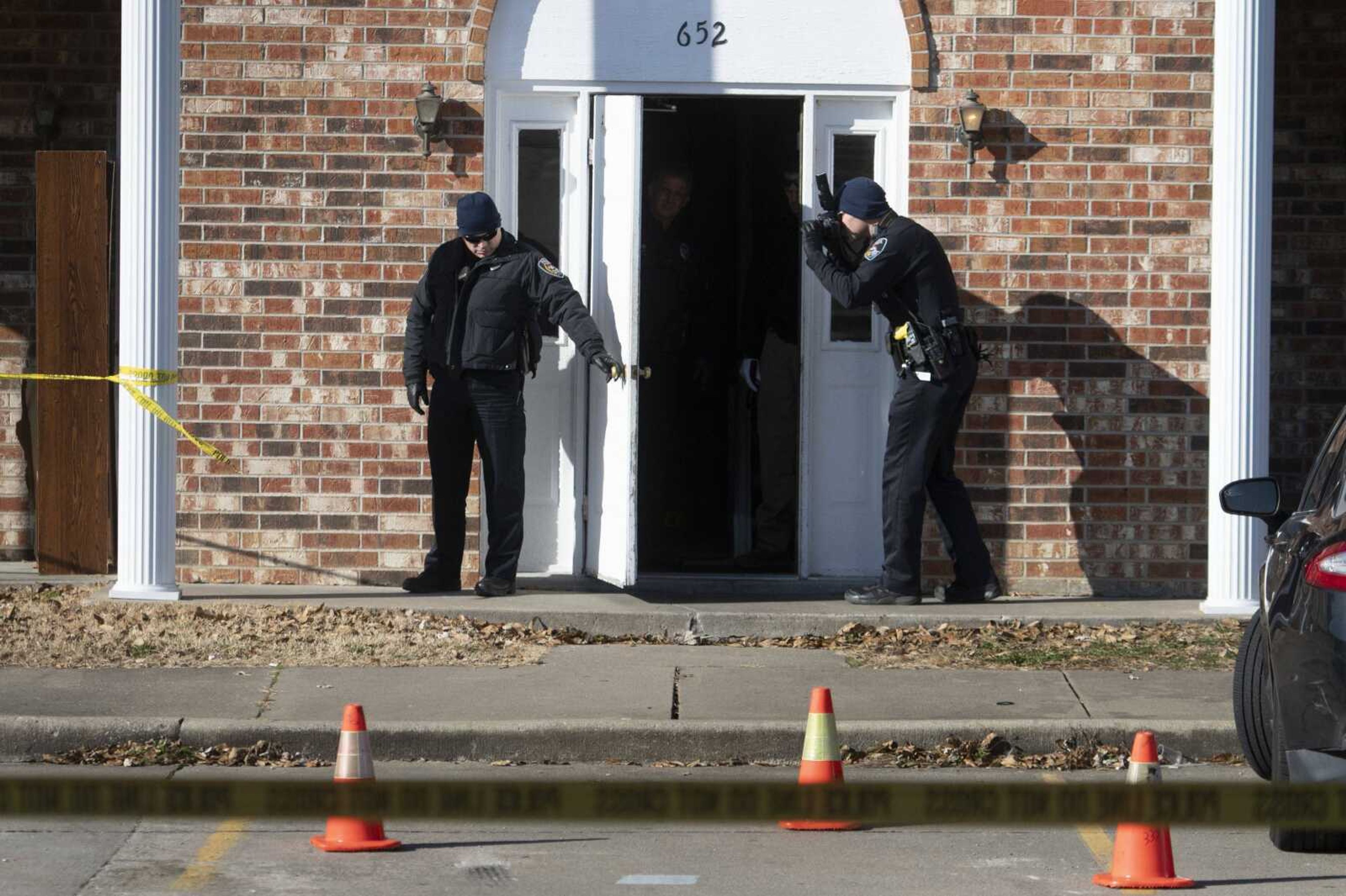 Cape Girardeau police Lt. Darren Estes holds a door as Cape Girardeau police Patrolman Andrew Simmons uses a camera following a shooting Wednesday, Dec. 11, 2019, at 652 South Spring St. in Cape Girardeau.