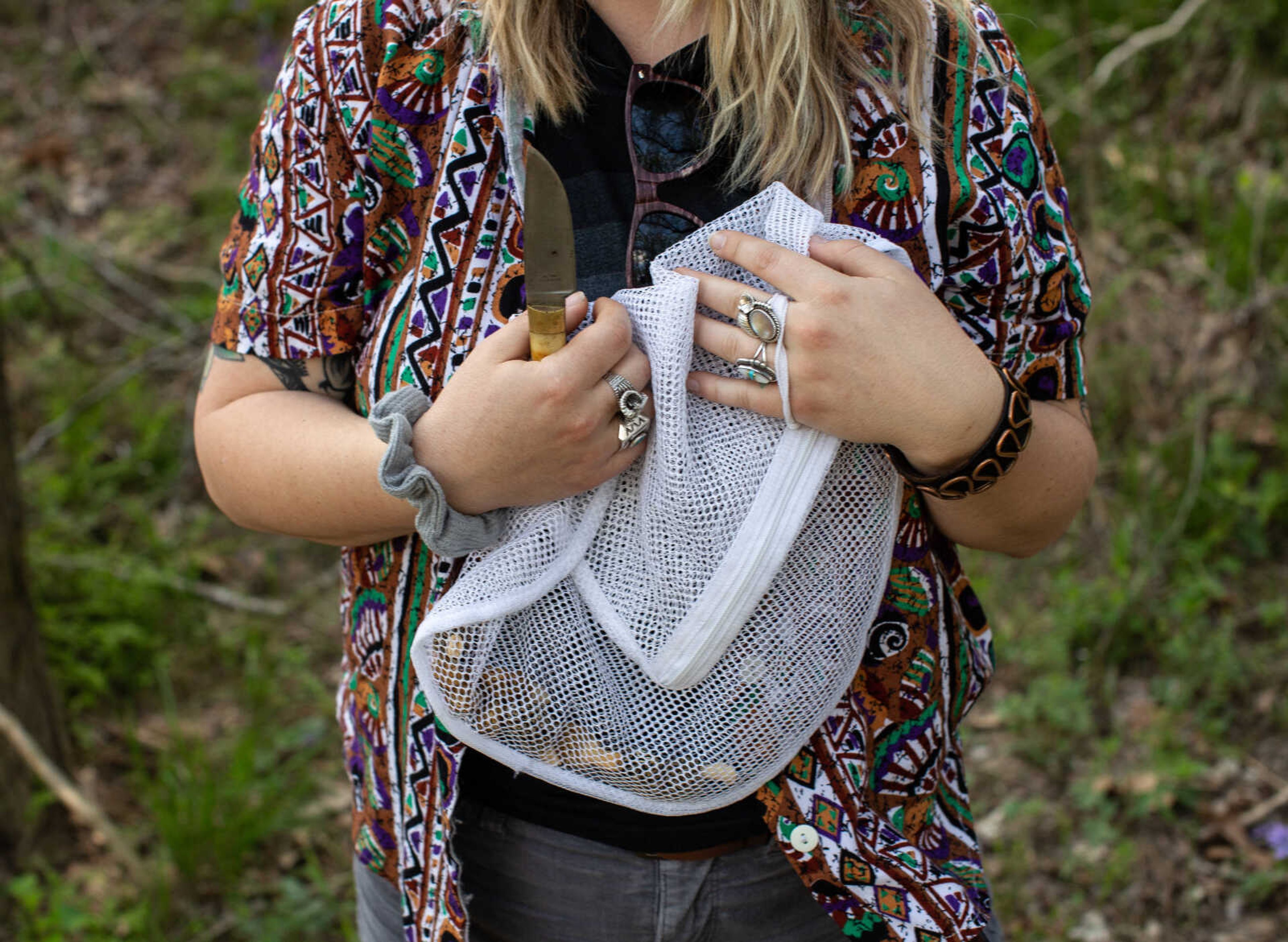 Anna Mae Zembsch holds a mesh laundry bag of morels after an afternoon of hunting. Zembsch describes their flavor as "nutty," and she says she usually satués them with butter and cayenne pepper or fries them.