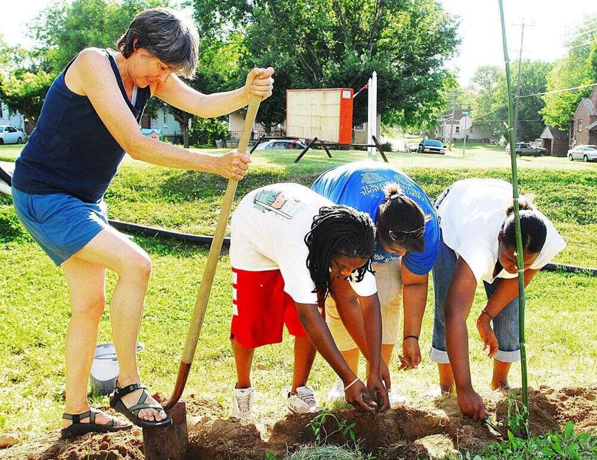 Mary Maginel dug a hole for another tomato plant as Khadijah Miller, 11, Perri Harrell, 16, and Takeesha Sessoms, 15, packed in dirt around others. (AARON EISENHAUER ~aeisenhauer@semissourian.com)