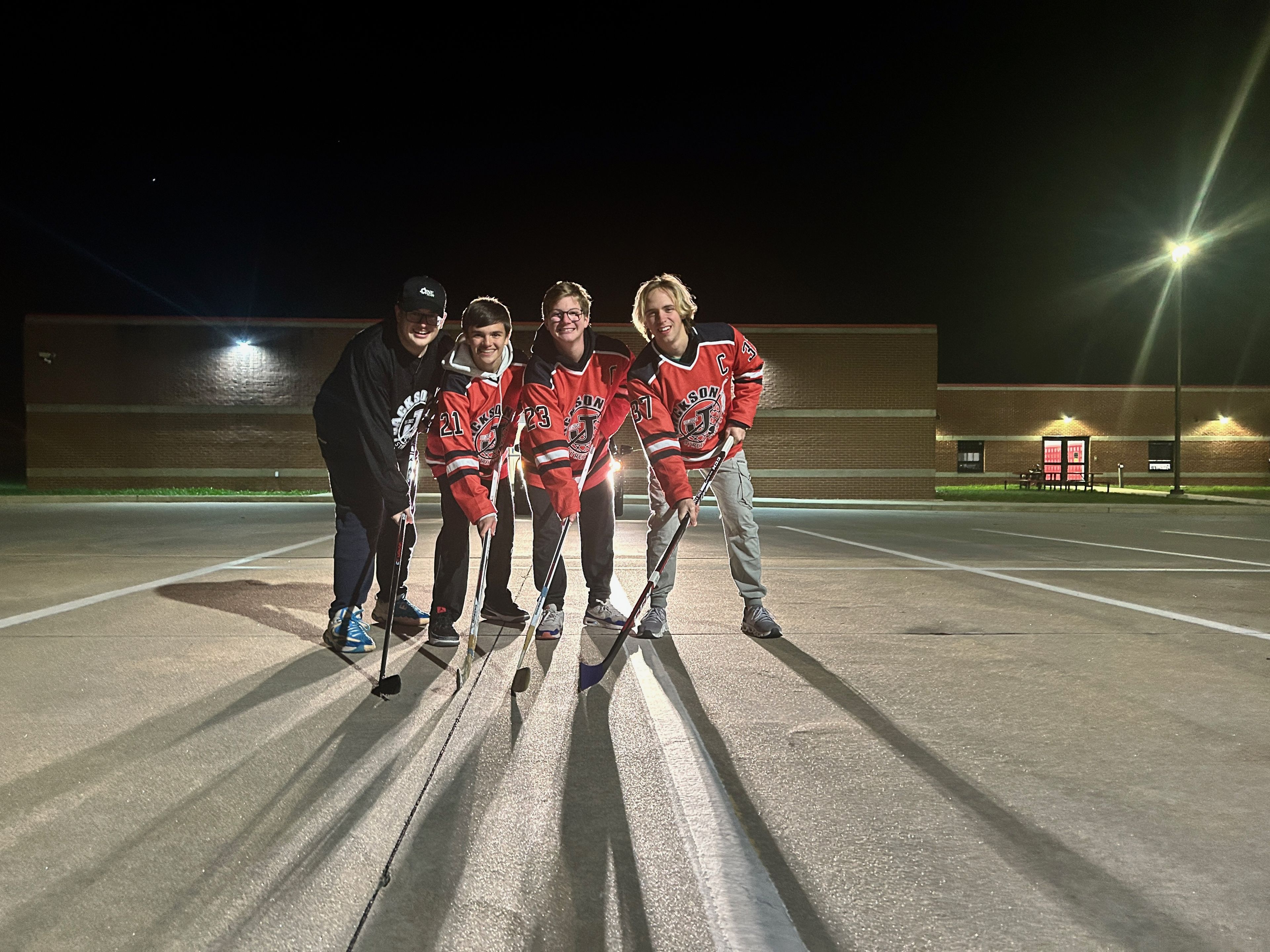 Members of Jackson Street Hockey, from left, Logan Maevers, Gavin Moyar, Jonathan Rosenquist and Brock Compton at the Jackson Middle School parking lot where they play hockey on Sundays. The organization raised money to fund a new hockey rink in Jackson City Park.