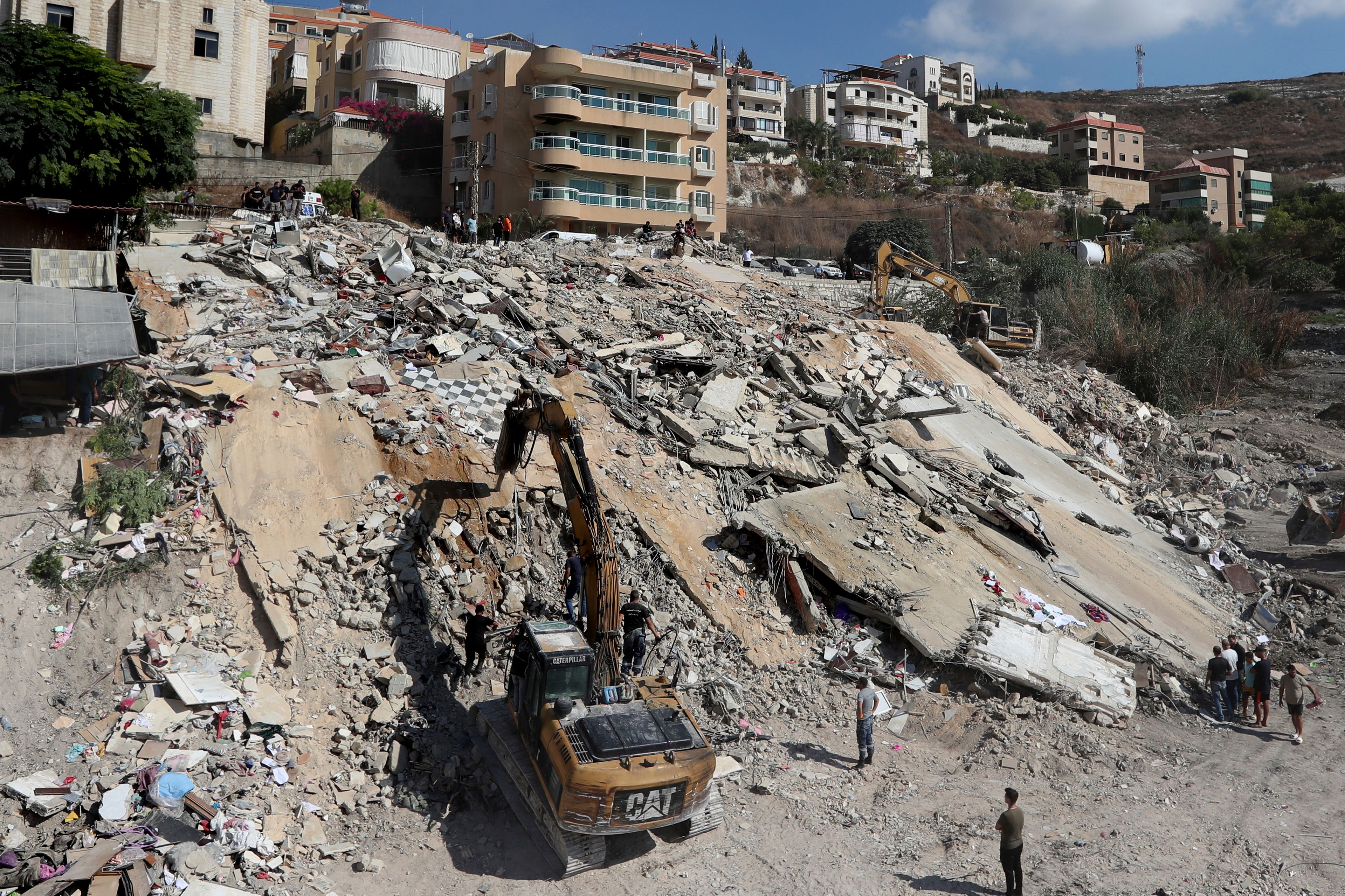 An excavator removes the rubble of a destroyed building that was hit on Sept. 29 by an Israeli airstrike in Ain el Delb, where more than 70 people were killed in the first week of escalation between Israel and Hezbollah, outside the southern port city of Sidon, Lebanon, Thursday, Oct. 10, 2024. (AP Photo/Mohammed Zaatari)