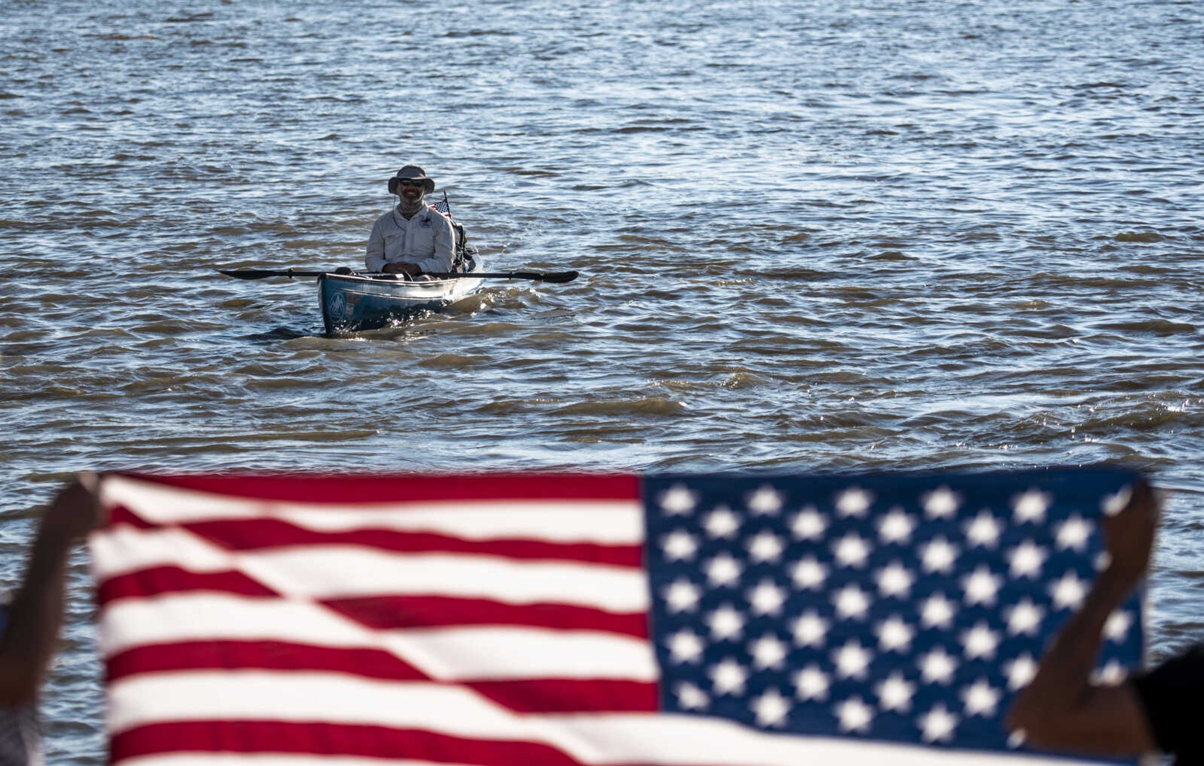 Rick Baine smiles while admiring a flag held up by Sue Kemp and Dale Humphries at the Cape Girardeau Riverfront Tuesday, Aug. 28, 2018 in Cape Girardeau. Baine, along with Ryan Webb and Matt Roy (not pictured), are making their way down the Mississippi River as part of the Warrior Paddle Expedition, starting at the source of the Mississippi River, Lake Itasca, Minnesota, and ending in the Gulf of Mexico.