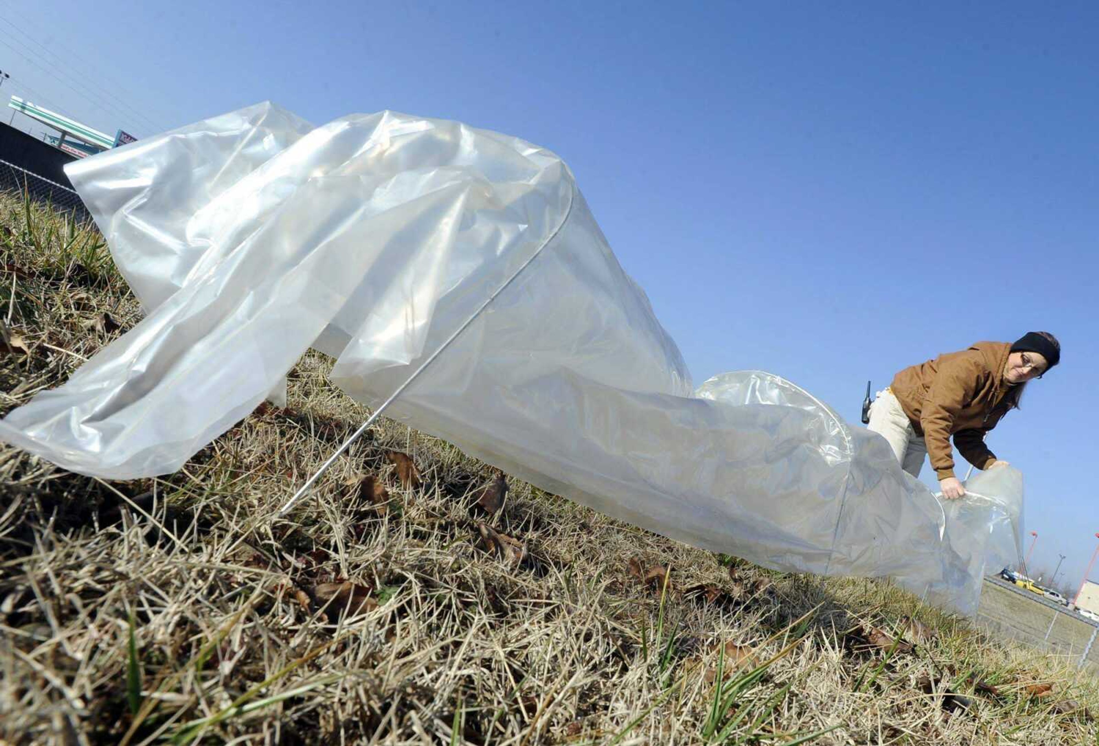 Melissa LaPlant shows a row cover that extends to 18 feet. It can protect plants from frost, wind chill and garden pests. (Fred Lynch)