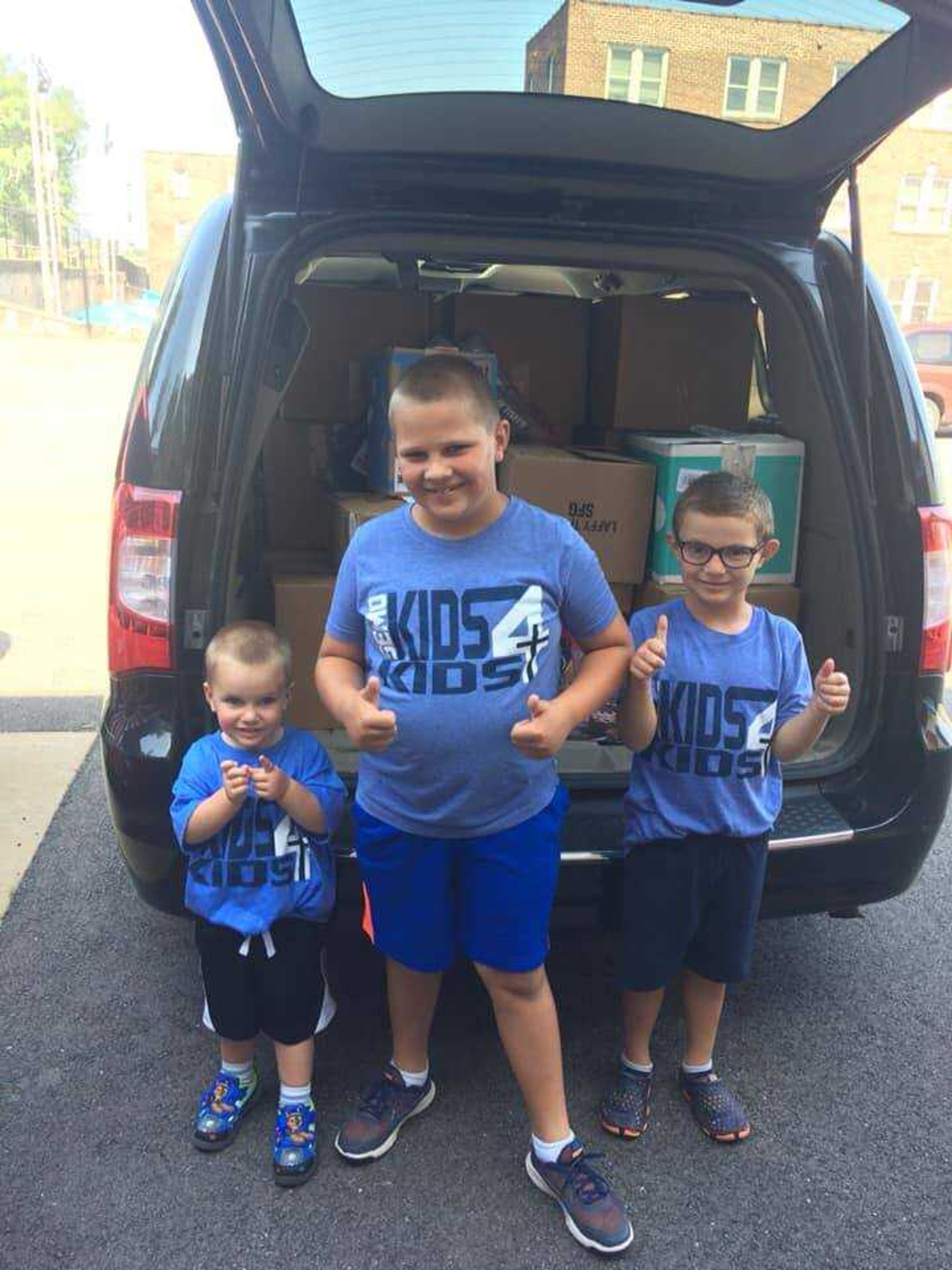 Brothers Tommy (2), Benny (7) and Danny (5) pose for a picture before unloading boxes at Cardinal Glennon Children's Hospital. 