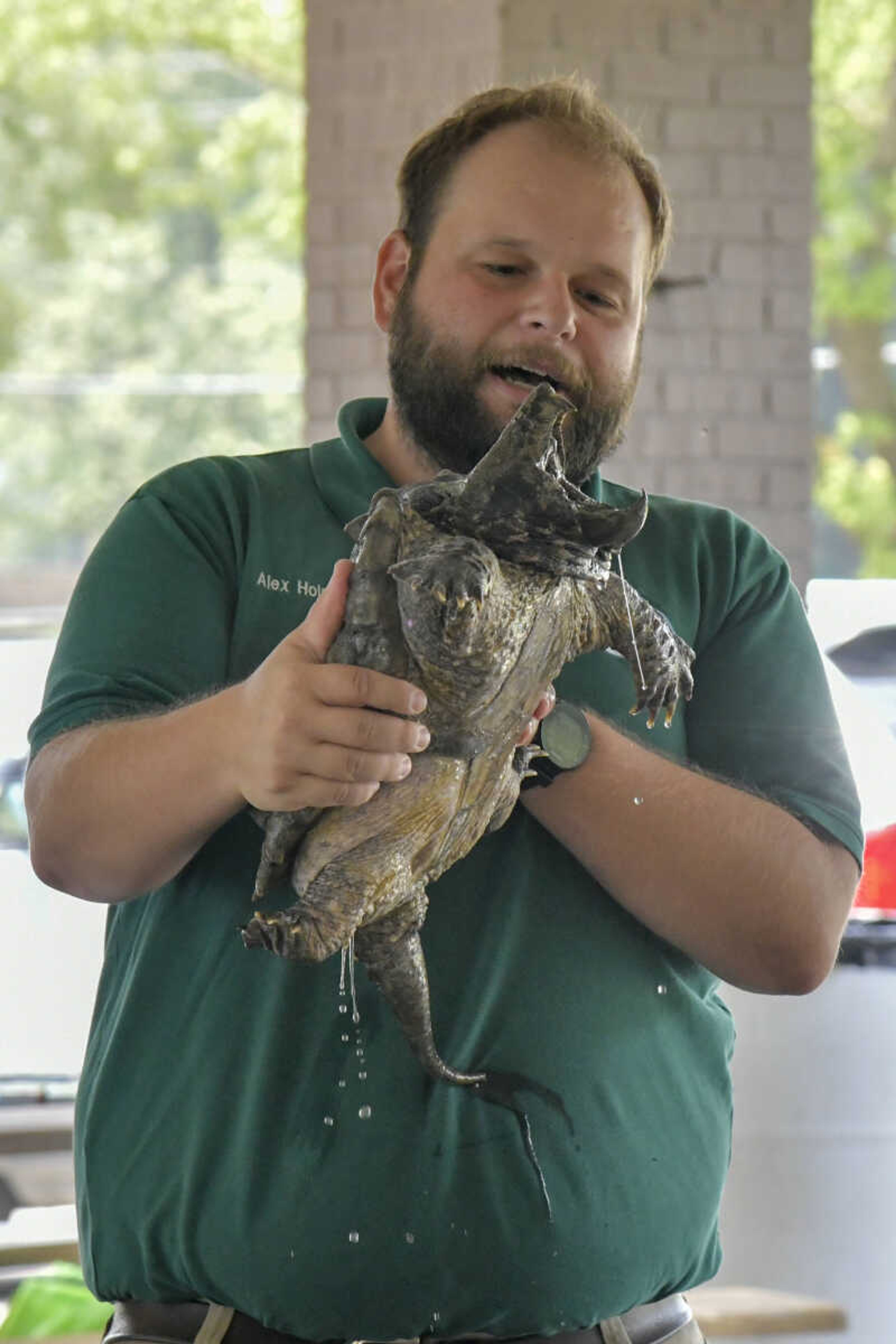 Naturalist for the Missouri Department of Conservation Alex Holmes holds an alligator snapping turtle during the EPIC Fun event at Arena Park in Cape Girardeau on Friday, July 23, 2021.