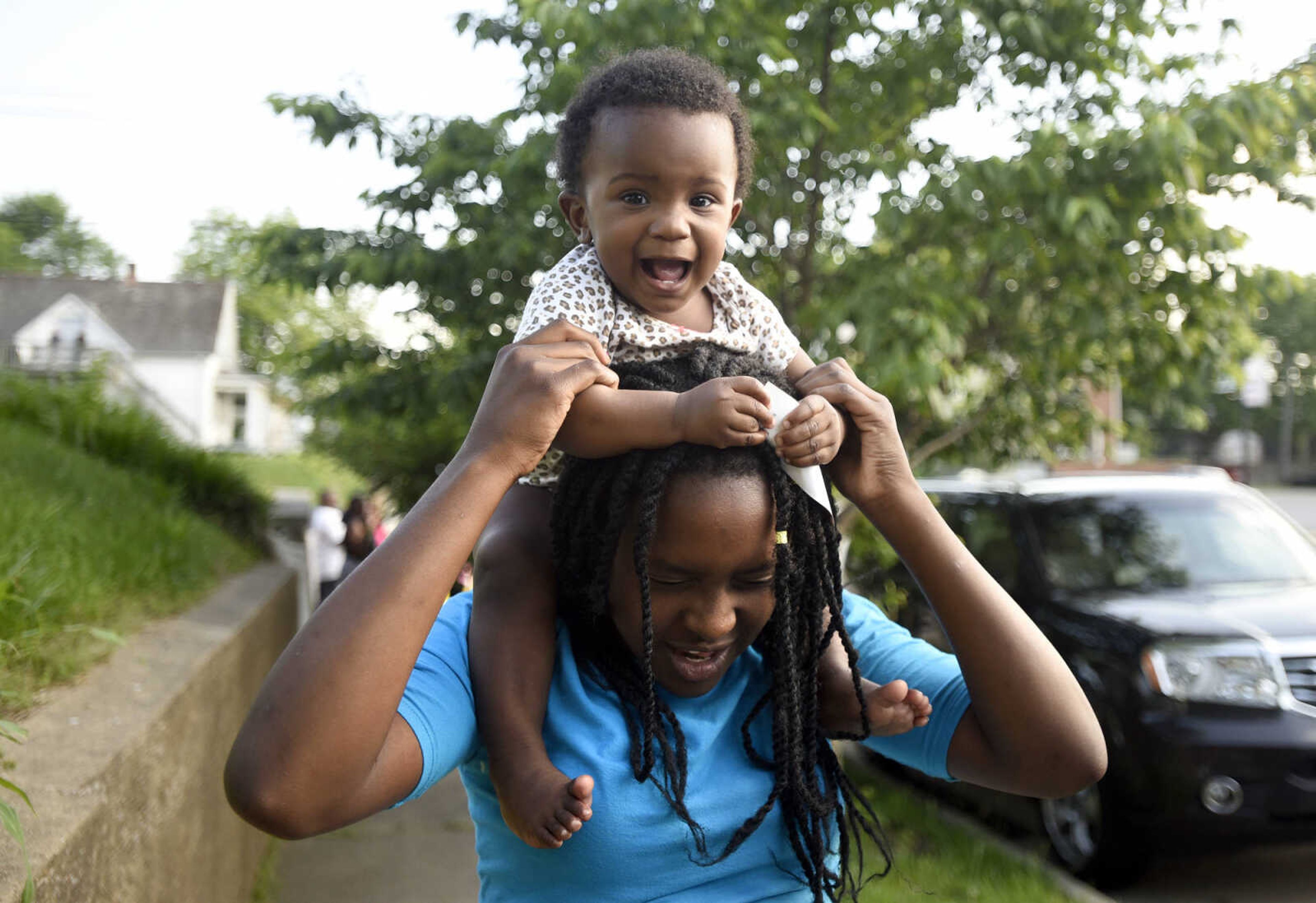 Sharayia anderson smiles as she sits on Shamariah Anderson's shoulders during a Stop Needless Acts of Violence Please(SNAP) community prayer on Tuesday, May 16, 2017, at the corner of Independence Street and Henderson Ave. in Cape Girardeau.