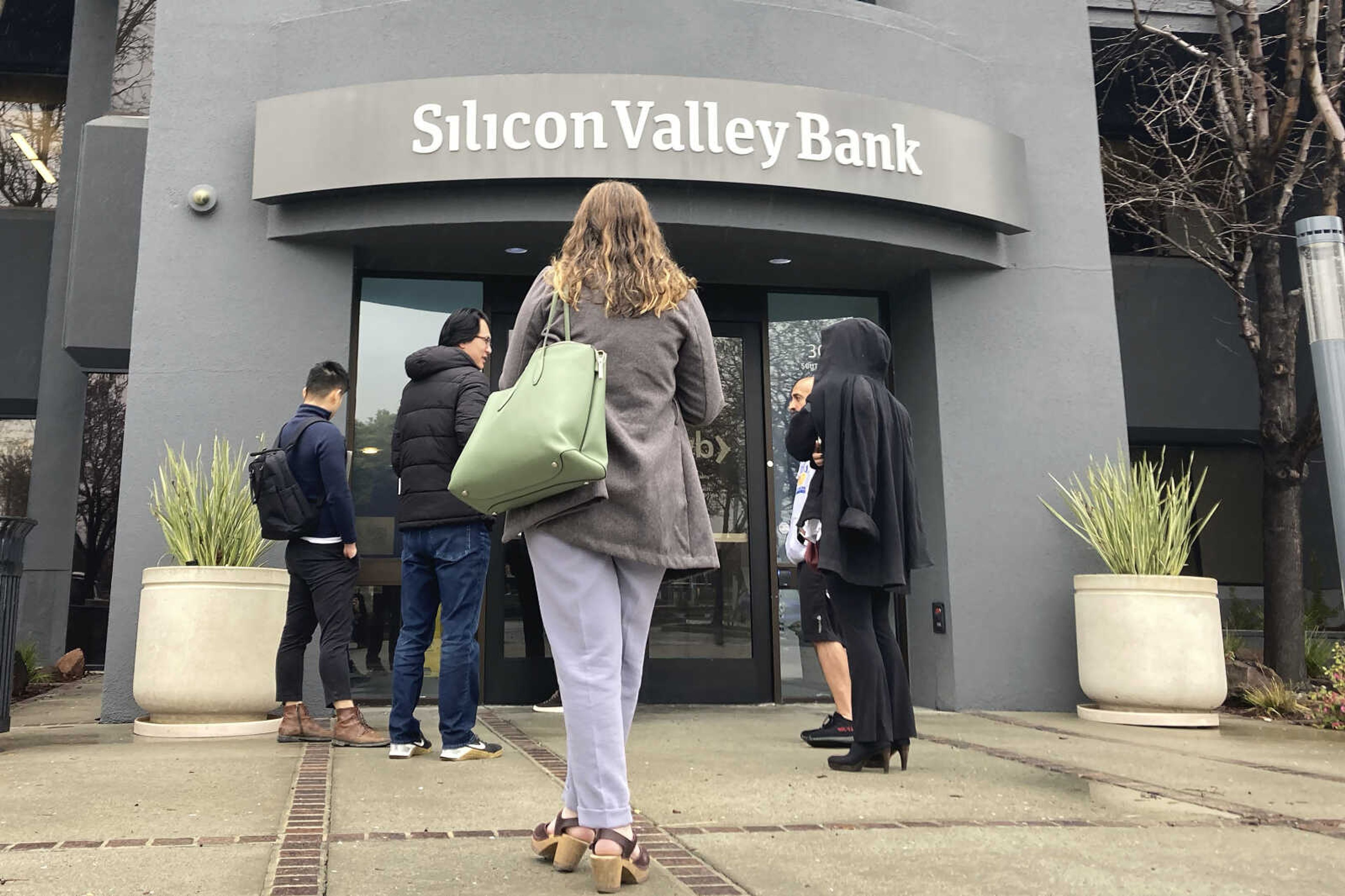 People stand outside a Silicon Valley Bank branch March 10 in Santa Clara, California. On Friday, the Federal Reserve released a highly-anticipated review of its supervision of Silicon Valley Bank, the go-to bank for venture capital firms and technology startups that failed spectacularly in March.