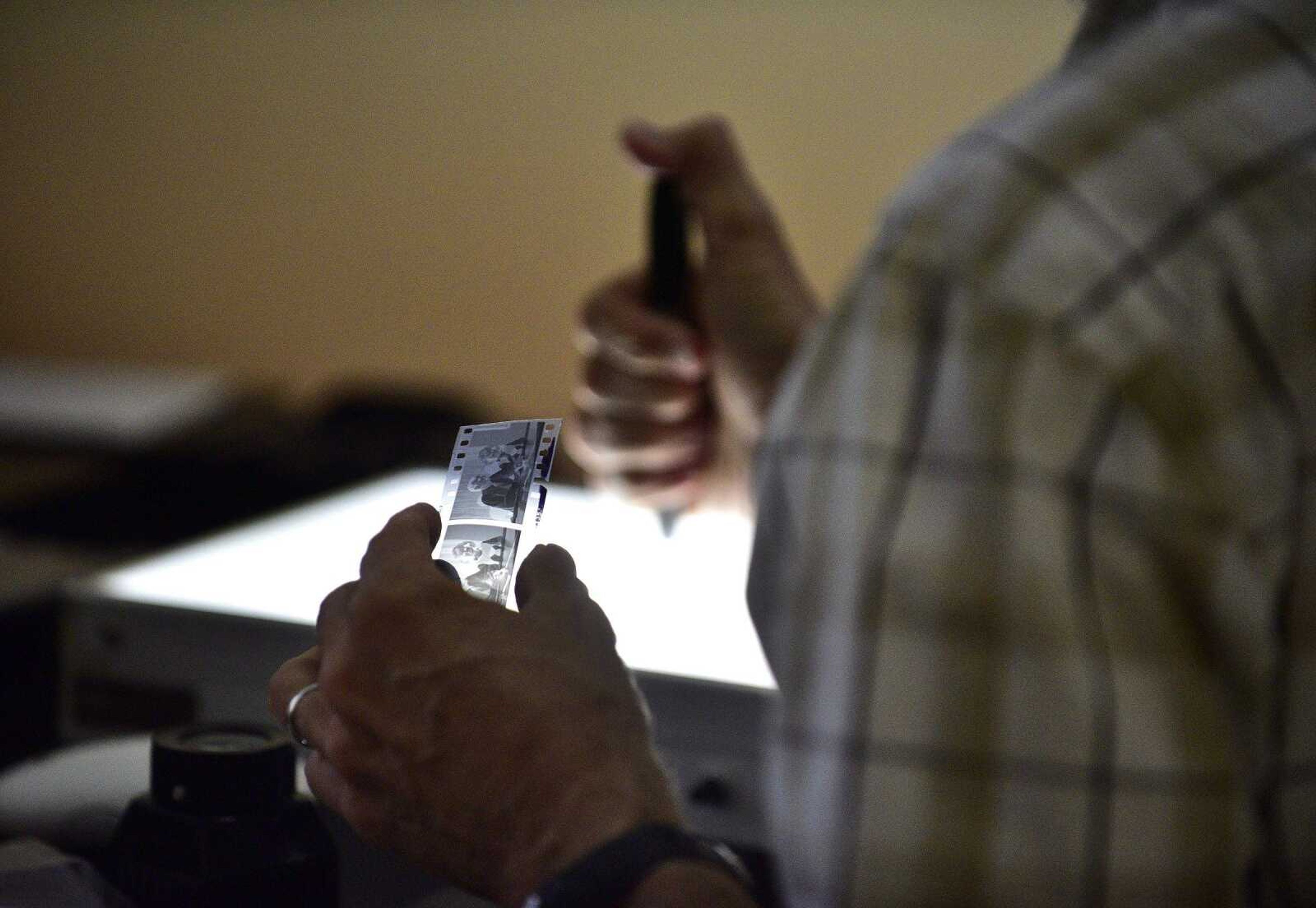 Southeast Missourian photojournalist, Fred Lynch, looks through a sleeve of old black and white negatives in the photo office on Friday, June 9, 2017.