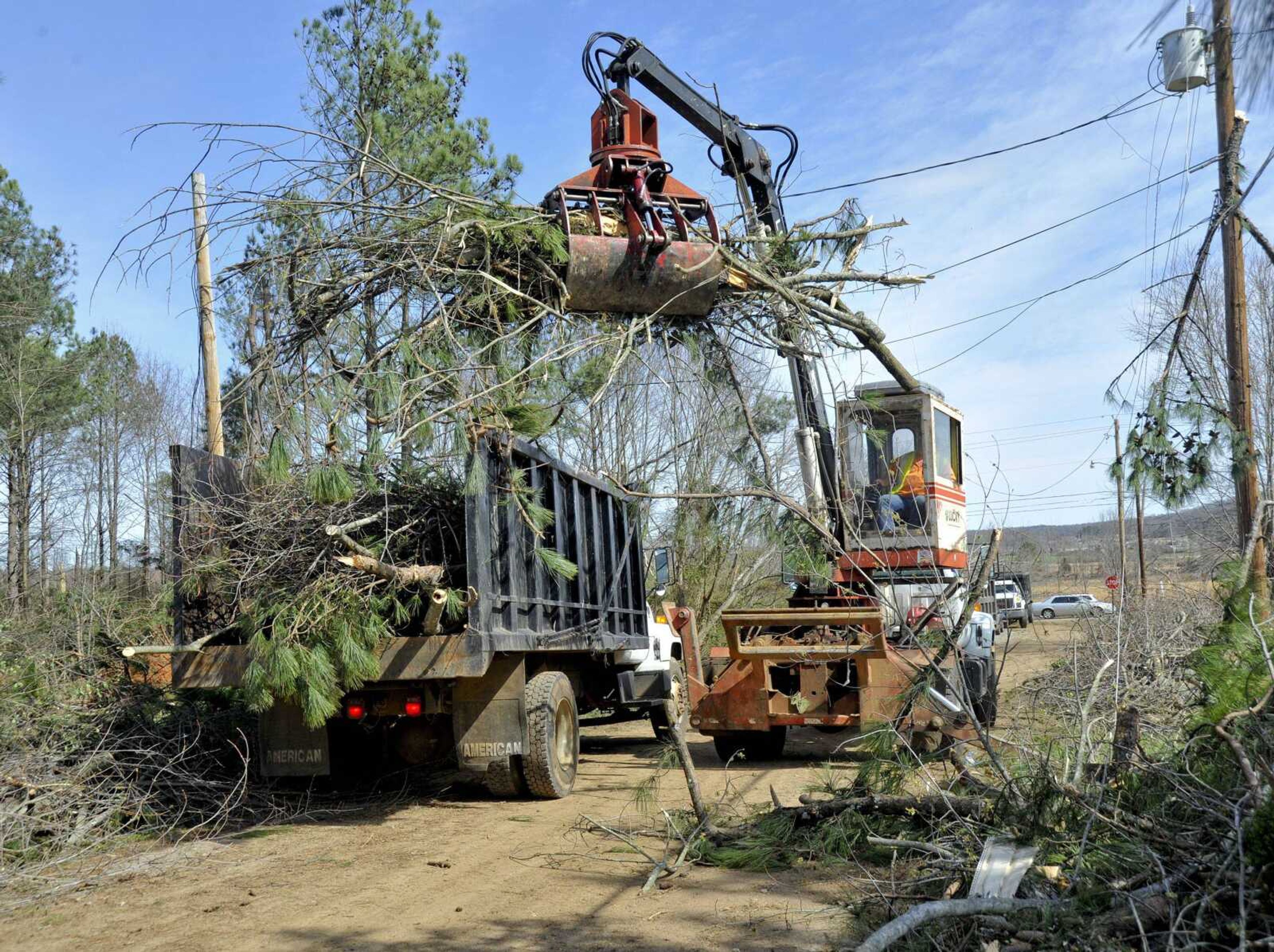 Madison County workers use a knuckle boom truck to pick up tornado debris Saturday in Harvest, Ala. Emergency crews searched for survivors Saturday after a violent wave of storms flattened some rural communities and left behind a trail of destruction. (Bob Gathany ~ The Huntsville Times)