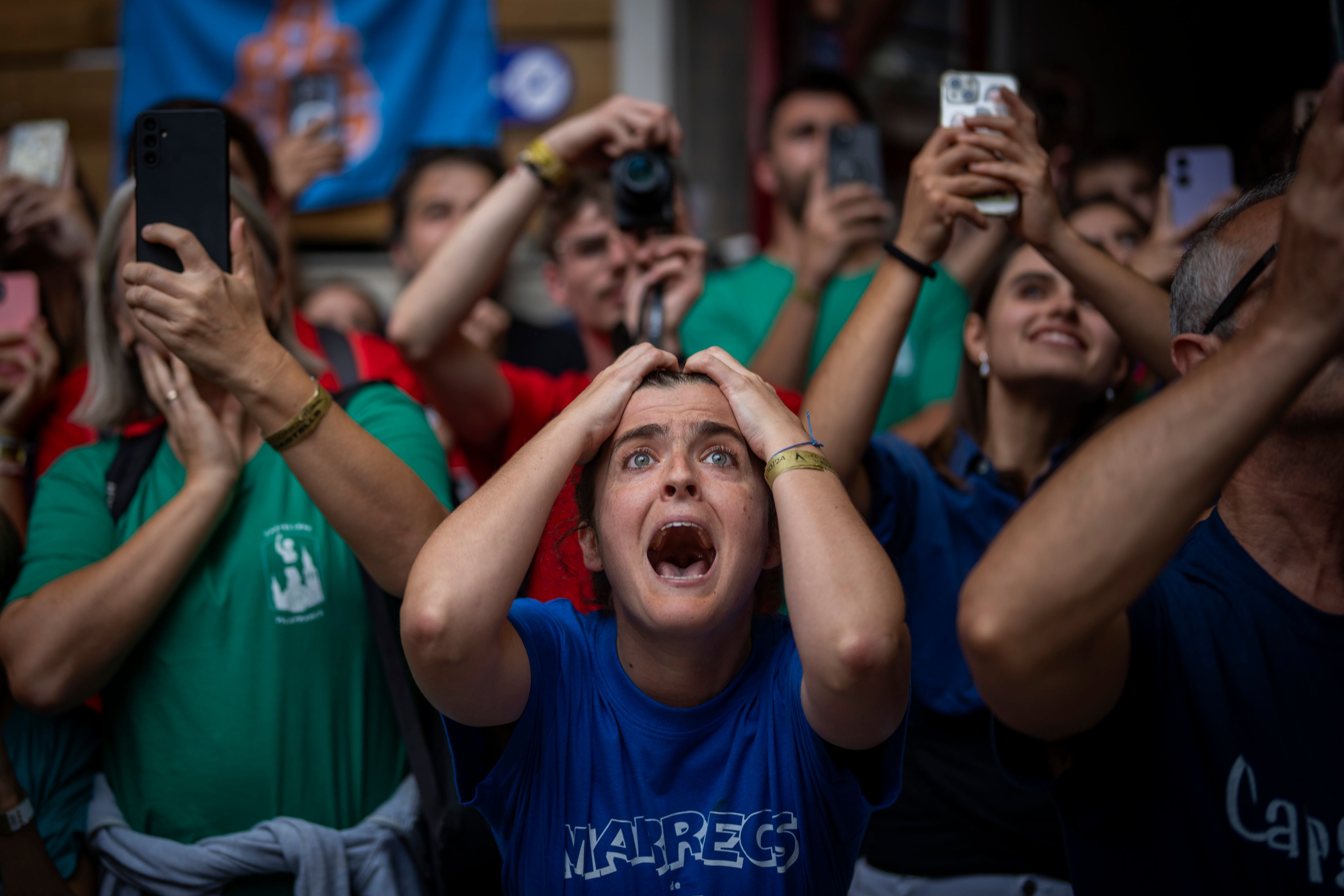 Assistants react as members of "Castellers de Vilafranca" try to form a "Castell" or human tower, during the 29th Human Tower Competition in Tarragona, Spain, on Oct. 6, 2024. (AP Photo/Emilio Morenatti)