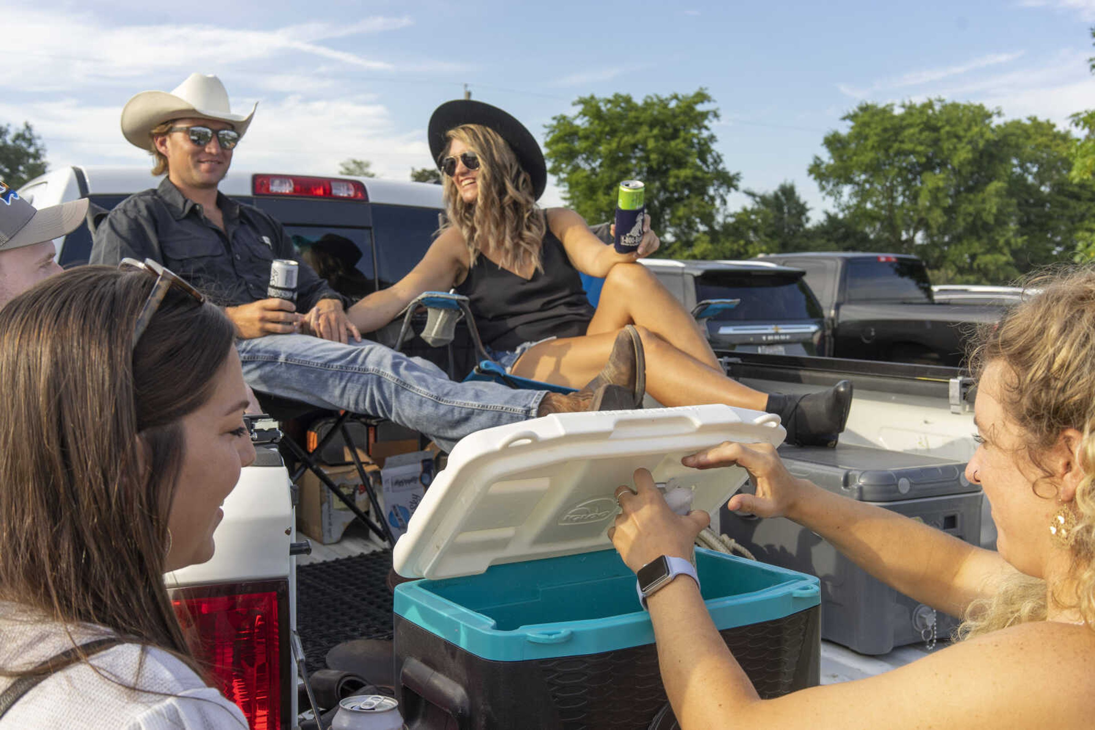 David Uptmor, left, and Kaelin Casasola of Cape Girardeau relax in style as Kelsey Tuschoff, right, grabs a refreshment before the last night of the Sikeston Jaycee Bootheel Rodeo Saturday, Aug. 14, 2021,&nbsp;in Sikeston, Missouri.